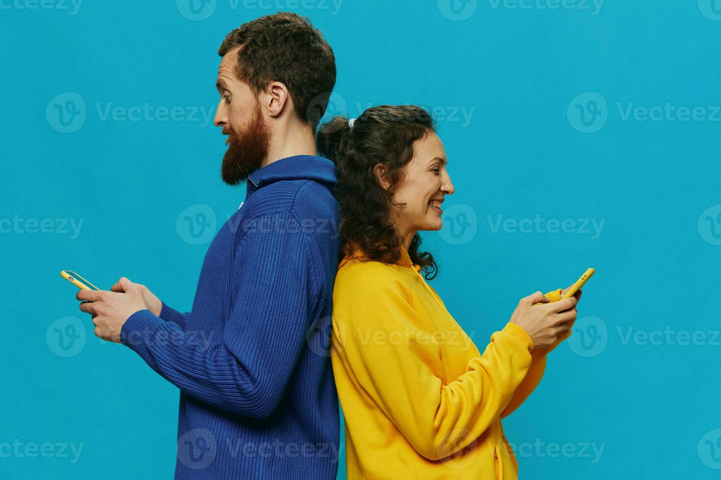 Woman and man cheerful couple with phones in their hands crooked smile cheerful, on blue background. The concept of real family relationships, talking on the phone, work online. photo