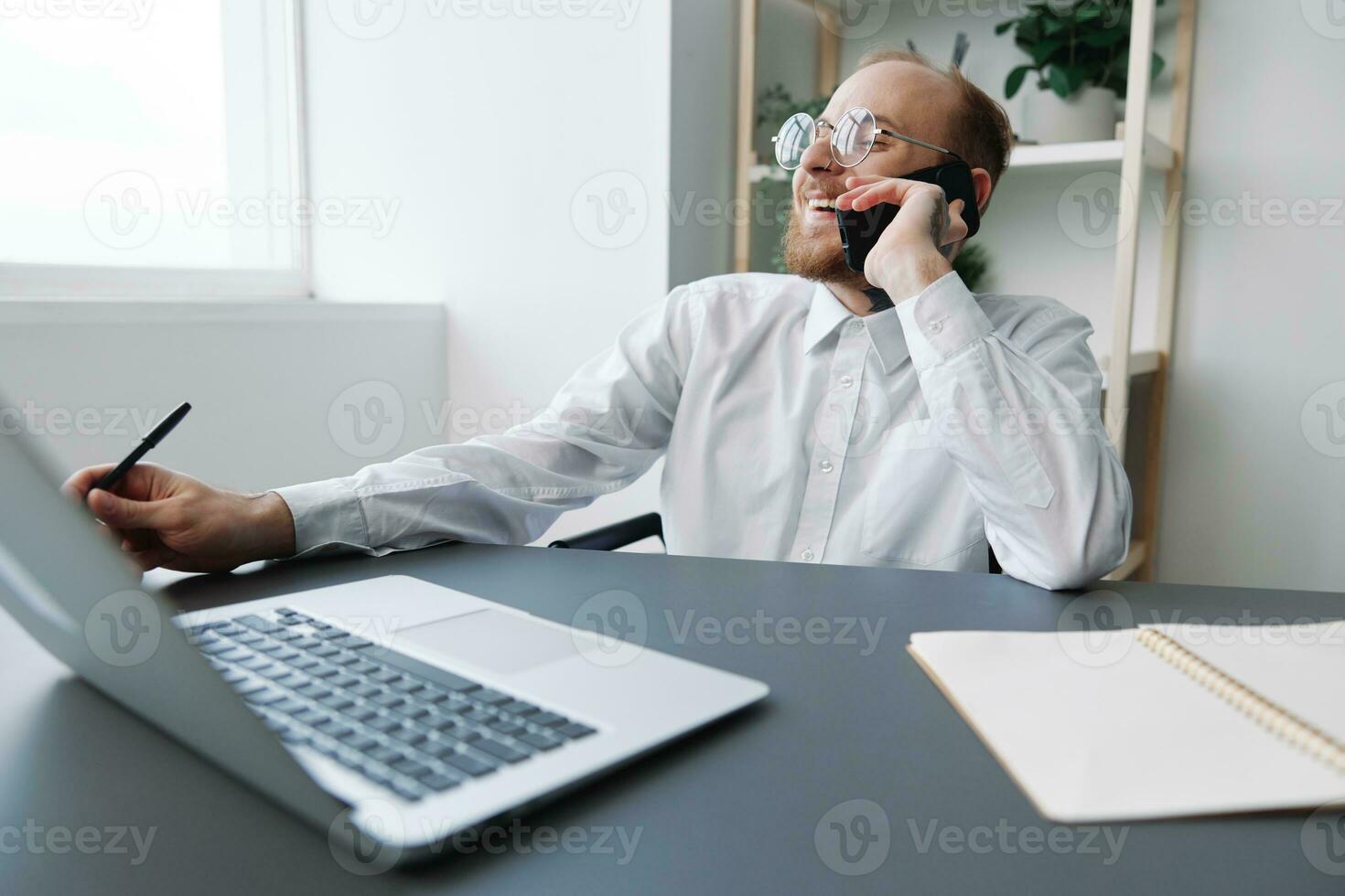 A man in a wheelchair businessman with tattoos in the office works, talking on the phone and smiling, integration into society, the concept of working a person with disabilities photo