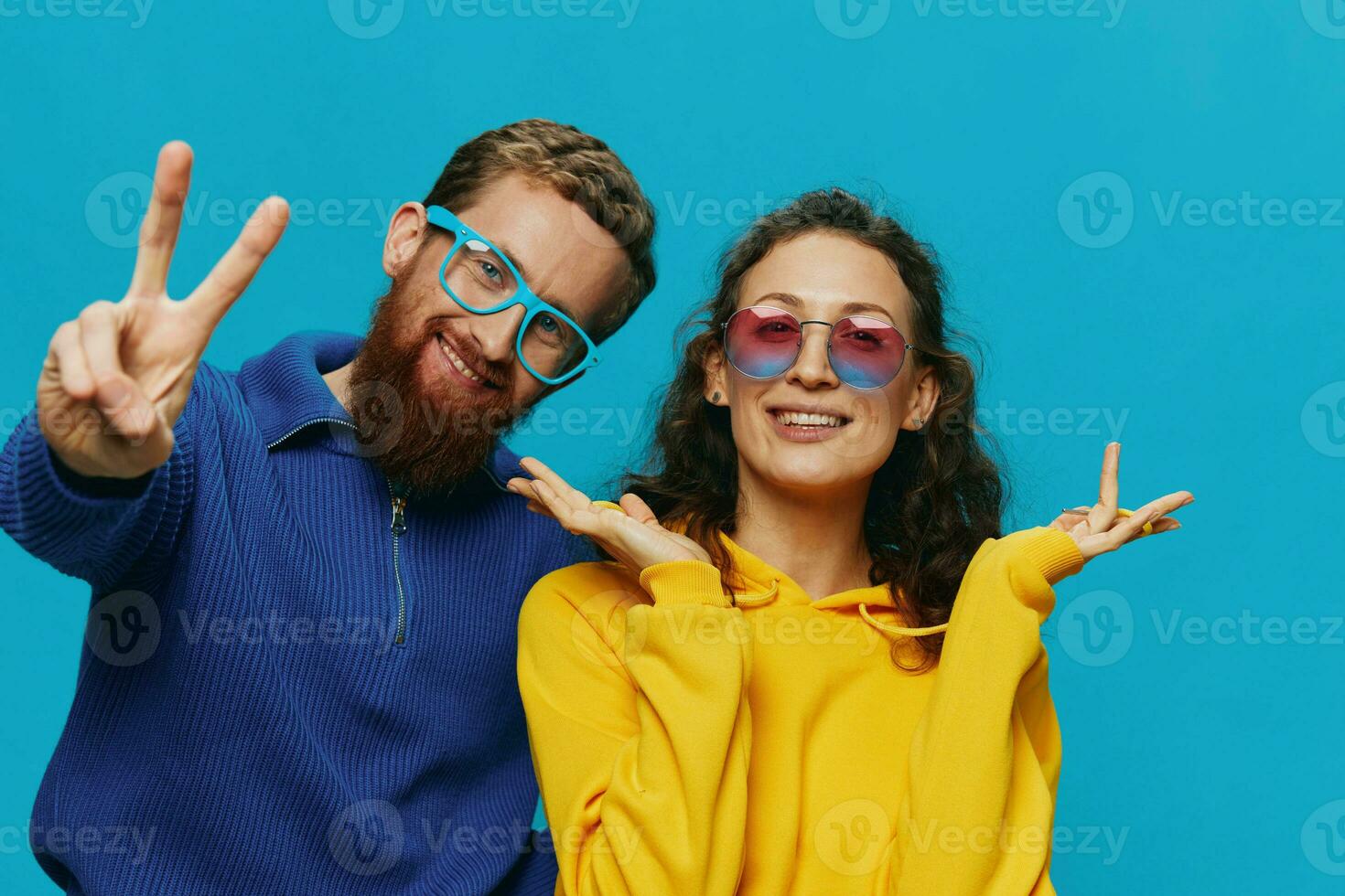 A woman and a man fun couple cranking and showing signs with their hands smiling cheerfully, on a blue background, The concept of a real relationship in a family. photo