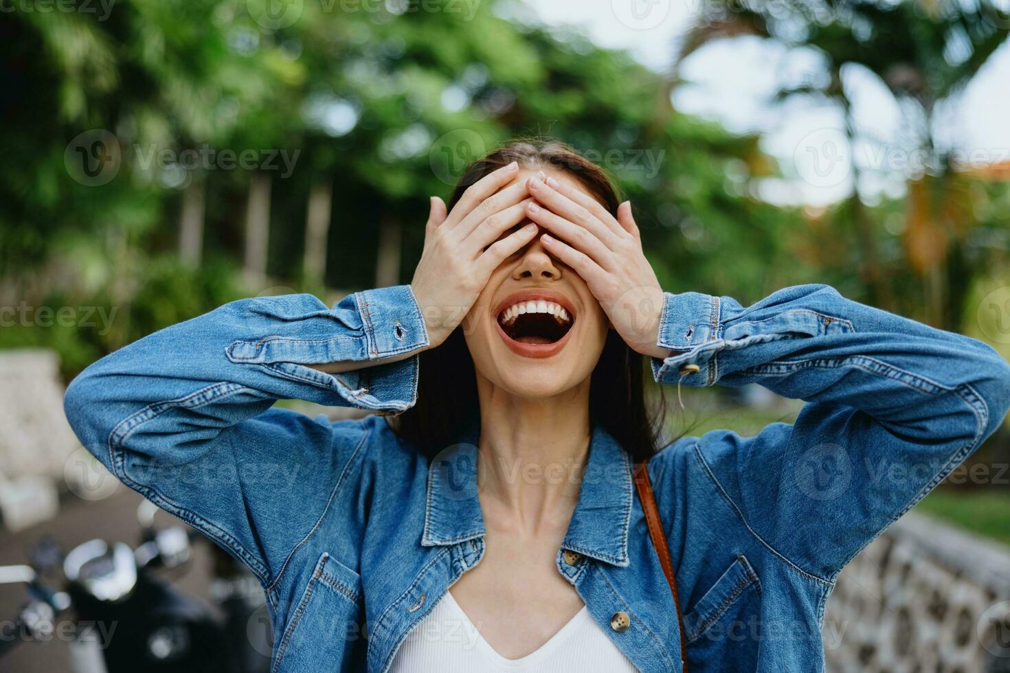 Portrait of a woman brunette smile with teeth walking outside against a backdrop of palm trees in the tropics, summer vacations and outdoor recreation, the carefree lifestyle of a freelance student. photo