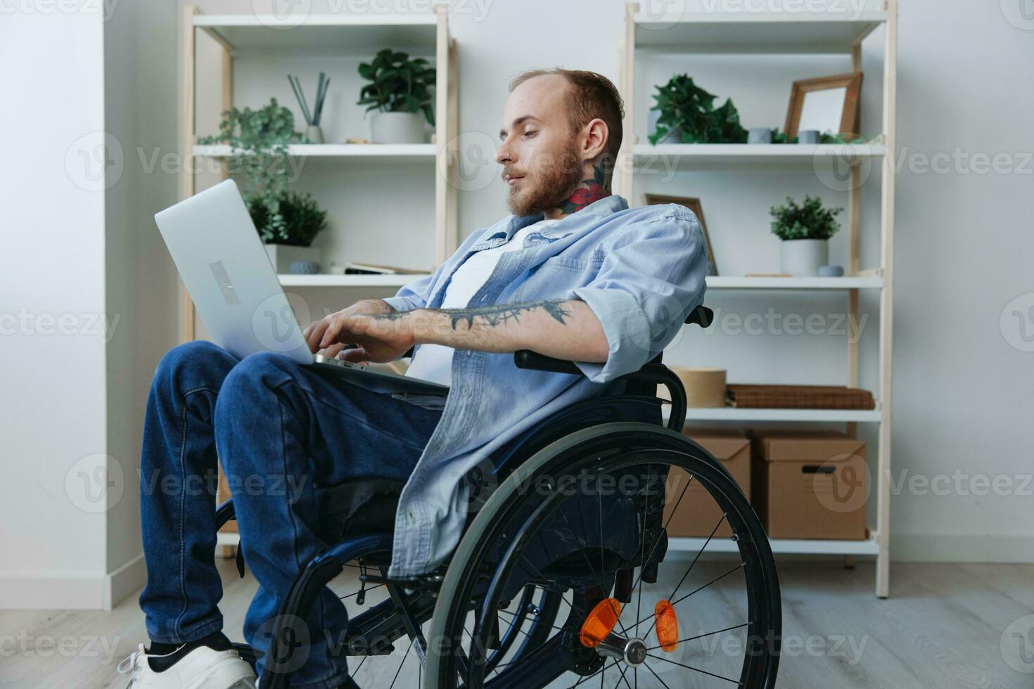 A man in a wheelchair freelancer works at a laptop at home, work online, social networks and startup, copy space, integration into society, concept of health disabled person, real person close-up photo