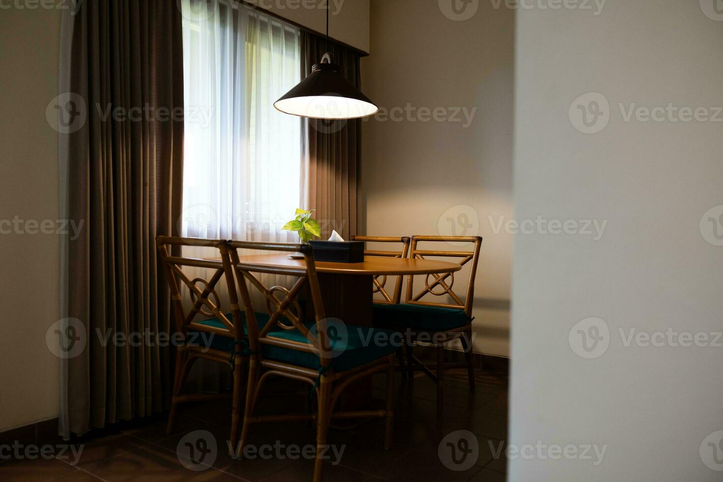 Dark home interior with wood dining table lit by lamp, evening light for dinner. photo