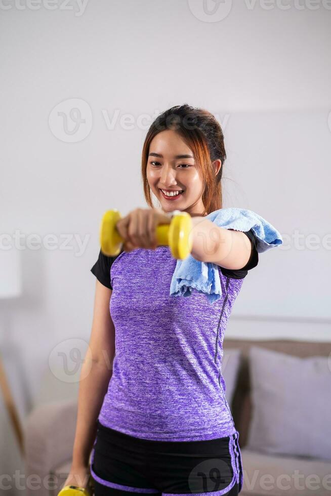 Asian woman exercising at home with swiss ball. home exercise concept. photo