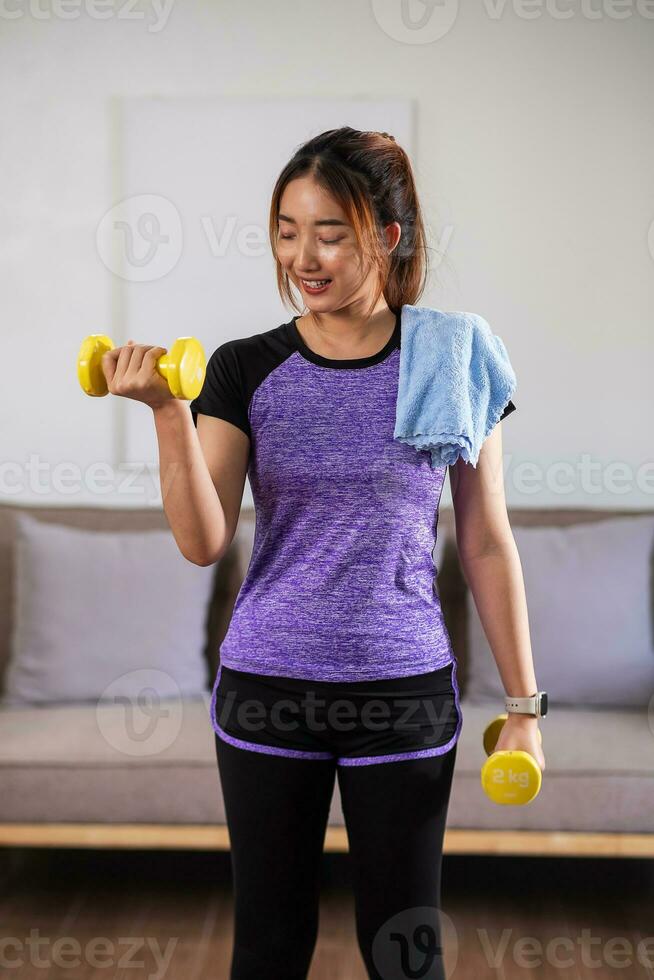 Asian woman exercising at home with swiss ball. home exercise concept. photo