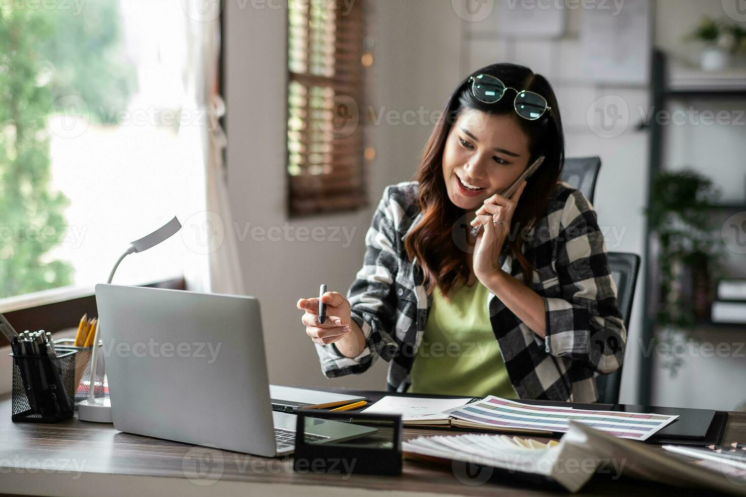 Graphic designer talk about work with mobile phone at office. photo