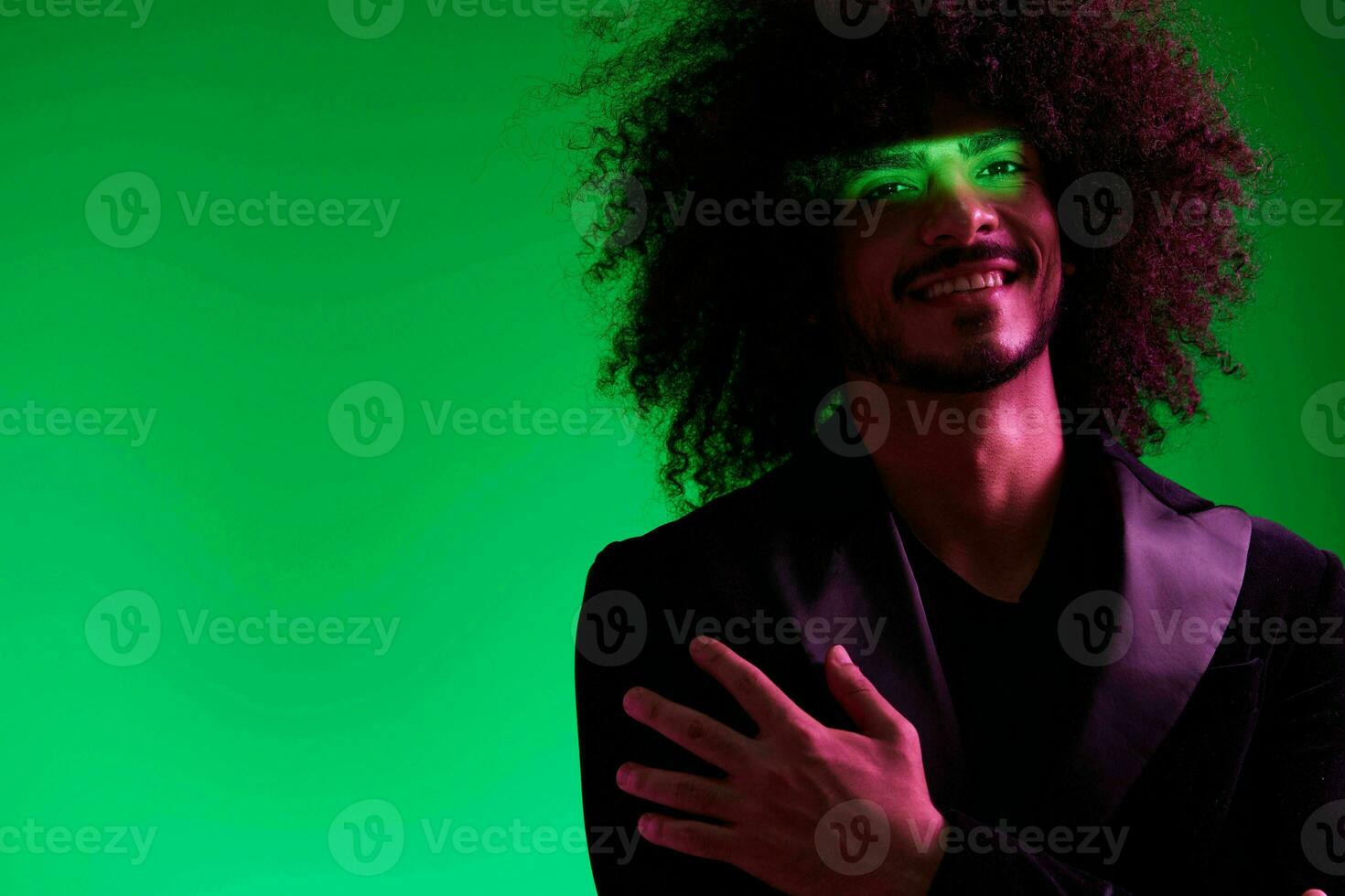 Portrait of a stylish man in a jacket on a green background multinational, color light, trend photo
