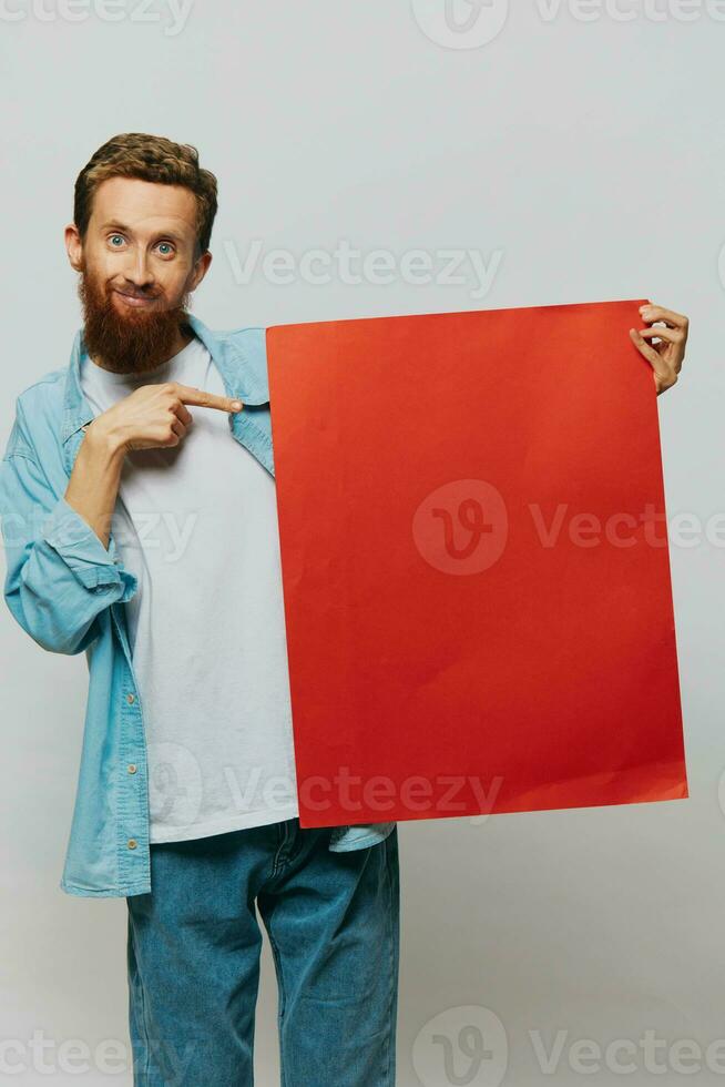 retrato de un adulto masculino en un gris antecedentes con un rojo pedazo de papel para tu diseño y texto, disposición, Copiar espacio, espacio para texto foto