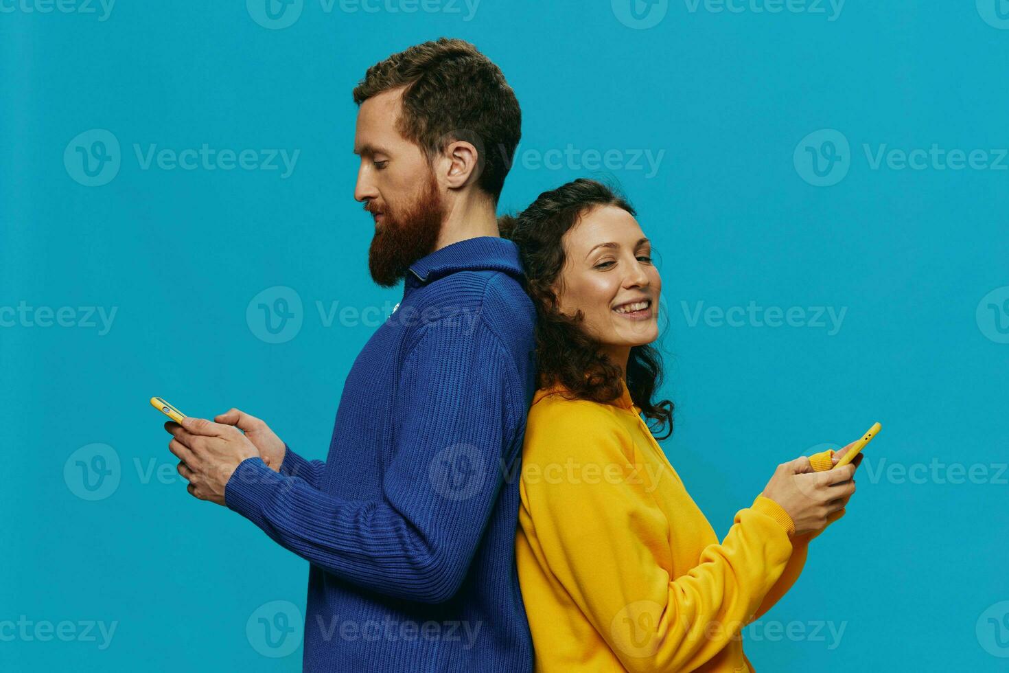 Woman and man cheerful couple with phones in their hands crooked smile cheerful, on blue background. The concept of real family relationships, talking on the phone, work online. photo