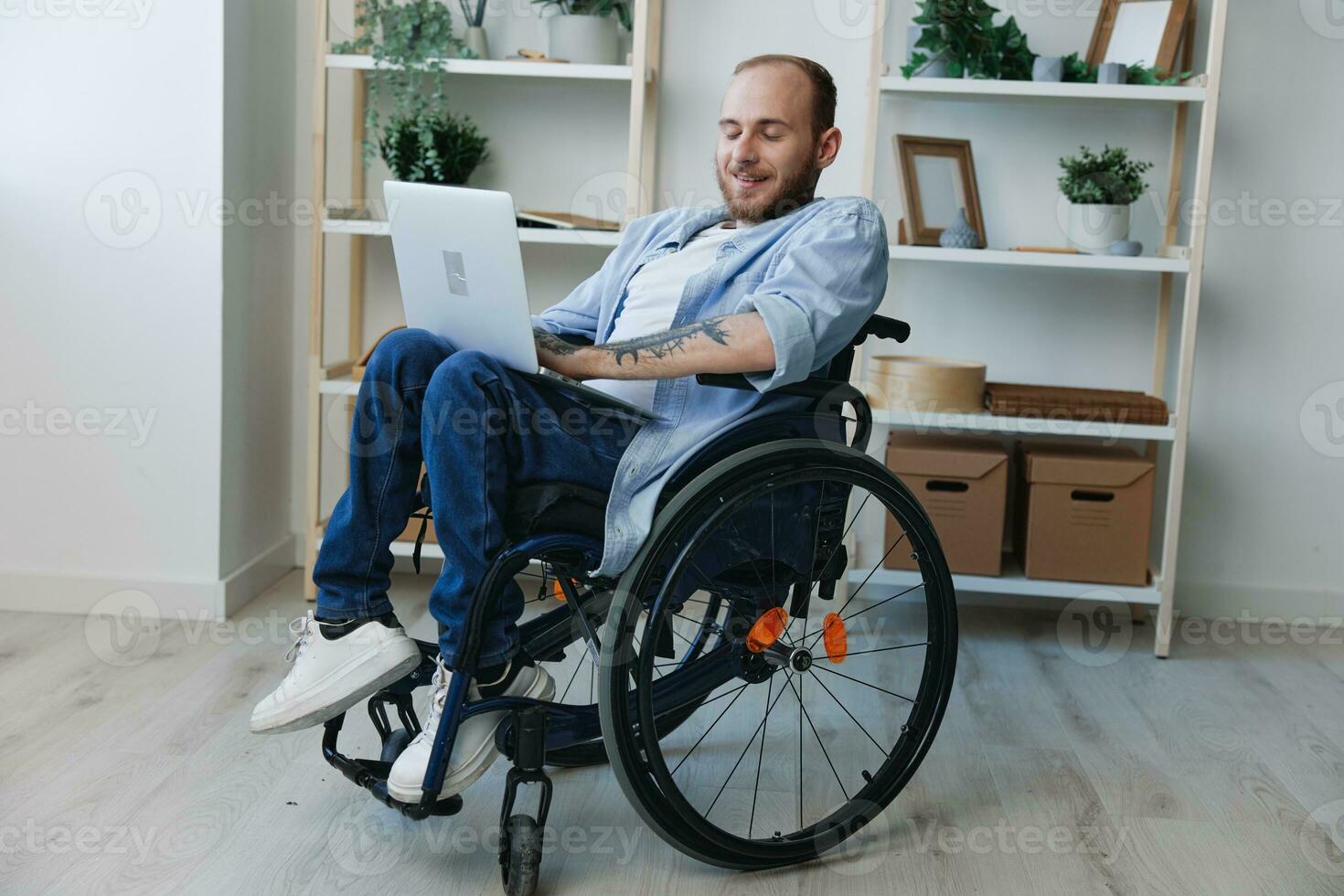 Man in wheelchair freelancer working at laptop at home smile, working online, social networks and startup, copy space, social integration, health concept man with disabilities, real person photo