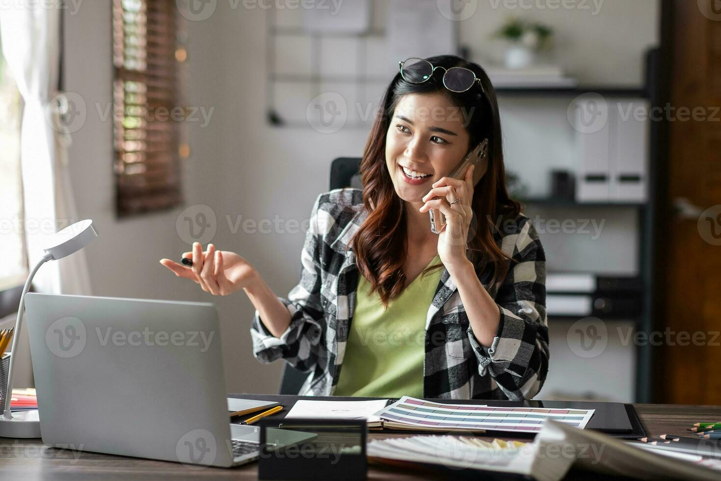 Graphic designer talk about work with mobile phone at office. photo