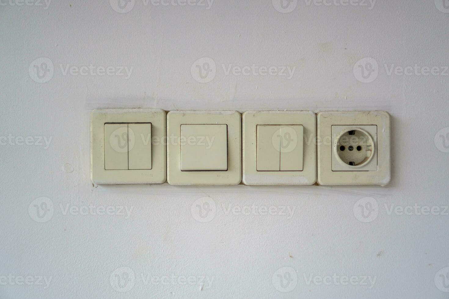 One socket and three switch. Electric socket and lamp switch button on the wall. photo