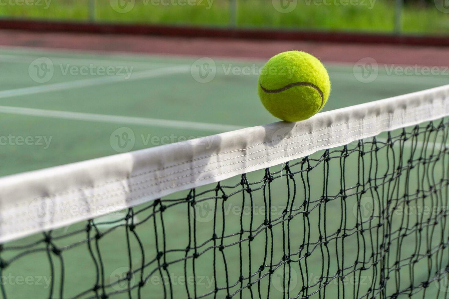 cerca arriba de tenis pelota clips el parte superior de el neto. tenis pelota golpear el red y va a el otro lado. foto