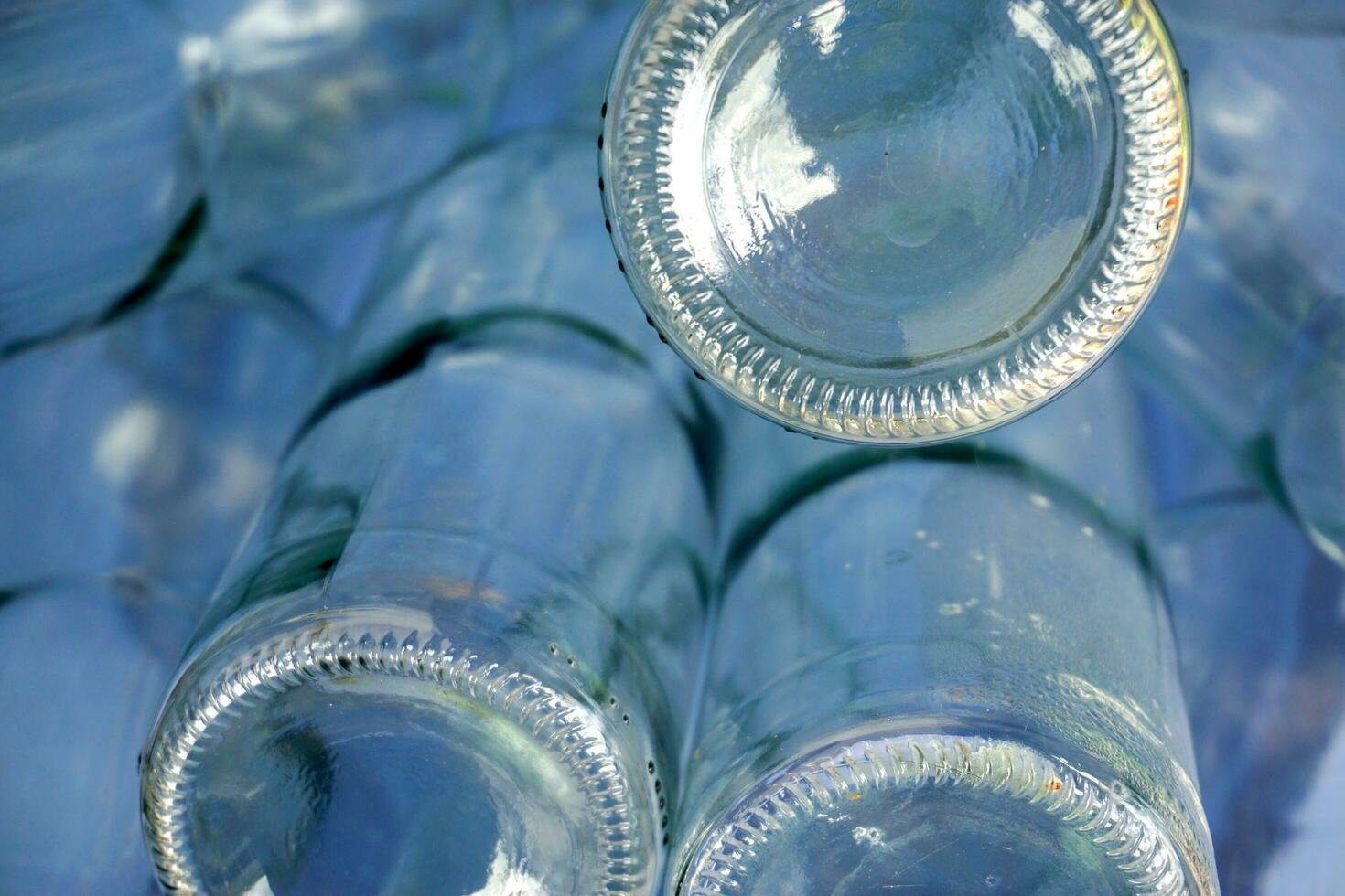 Closeup and crop bottom and up side down of glass bottle in full screen and blue background. photo