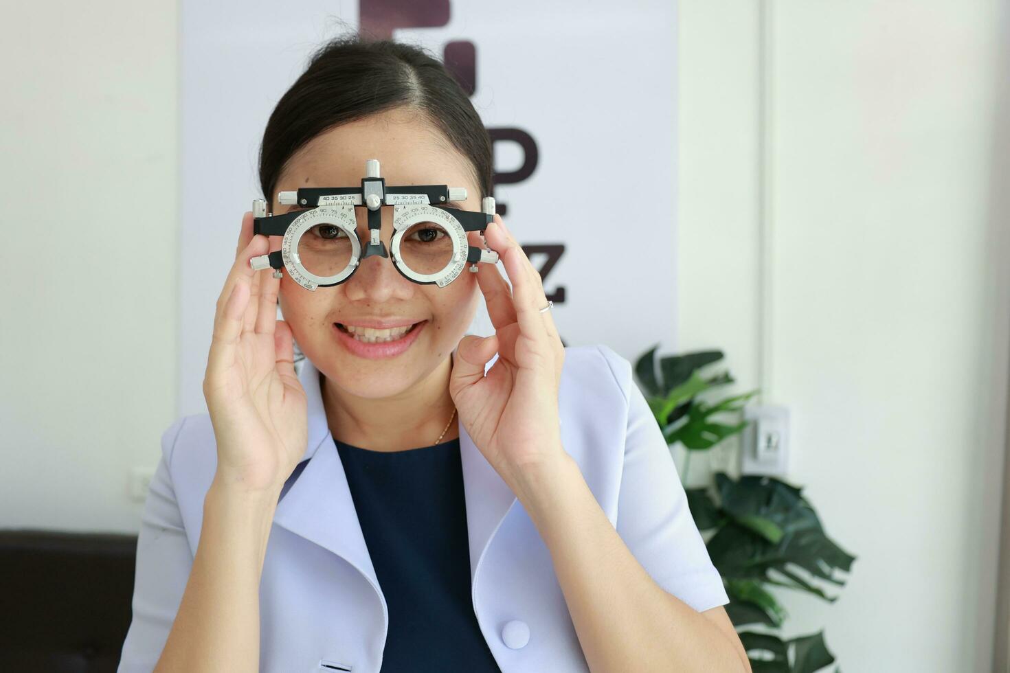 Female ophthalmologist holding eyeglasses inside clinic, eye doctor holding glasses in eyeglasses shop, Ophthalmologist holding eyeglasses in eyeglass clinic photo