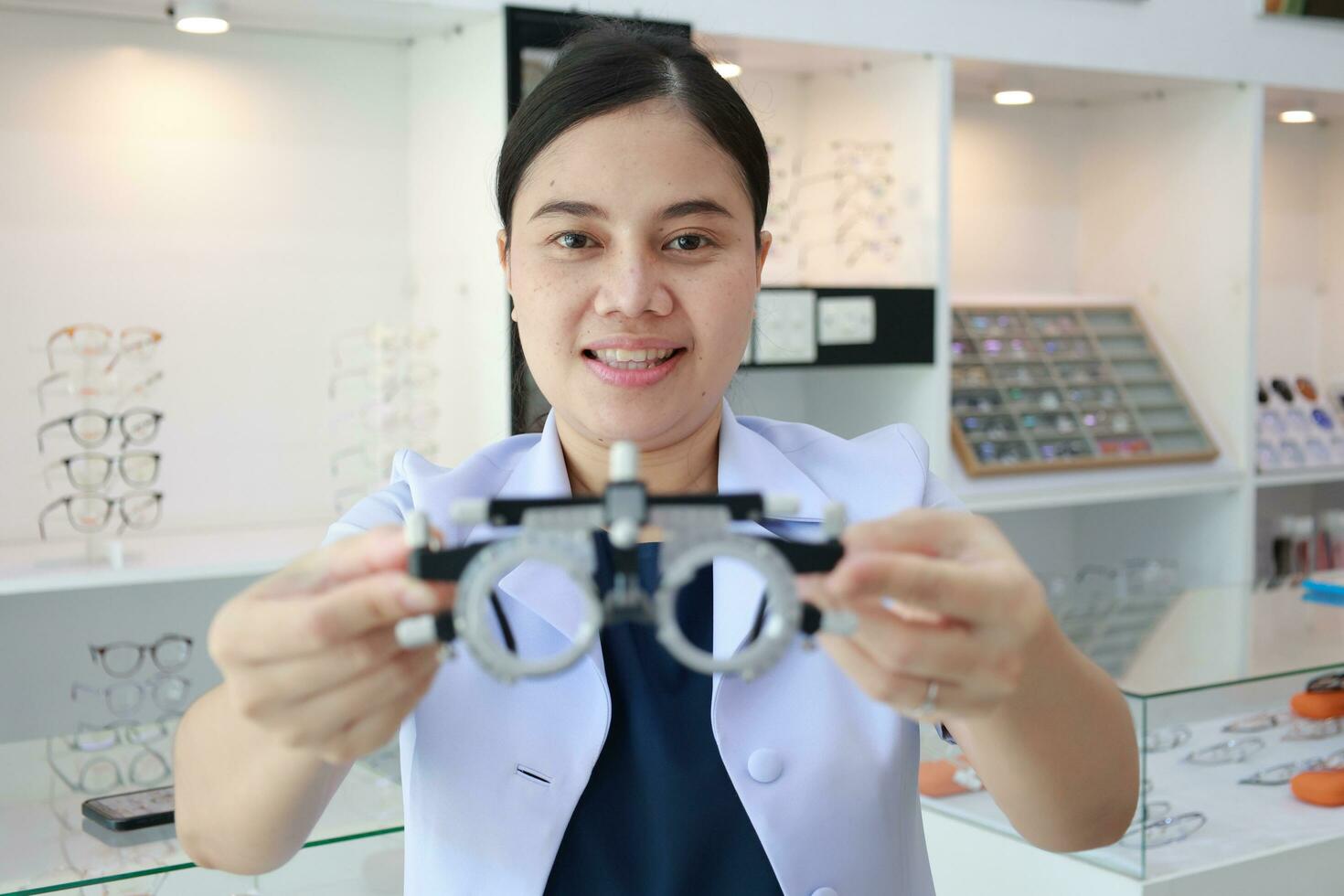 Female ophthalmologist holding eyeglasses inside clinic, eye doctor holding glasses in eyeglasses shop, Ophthalmologist holding eyeglasses in eyeglass clinic photo