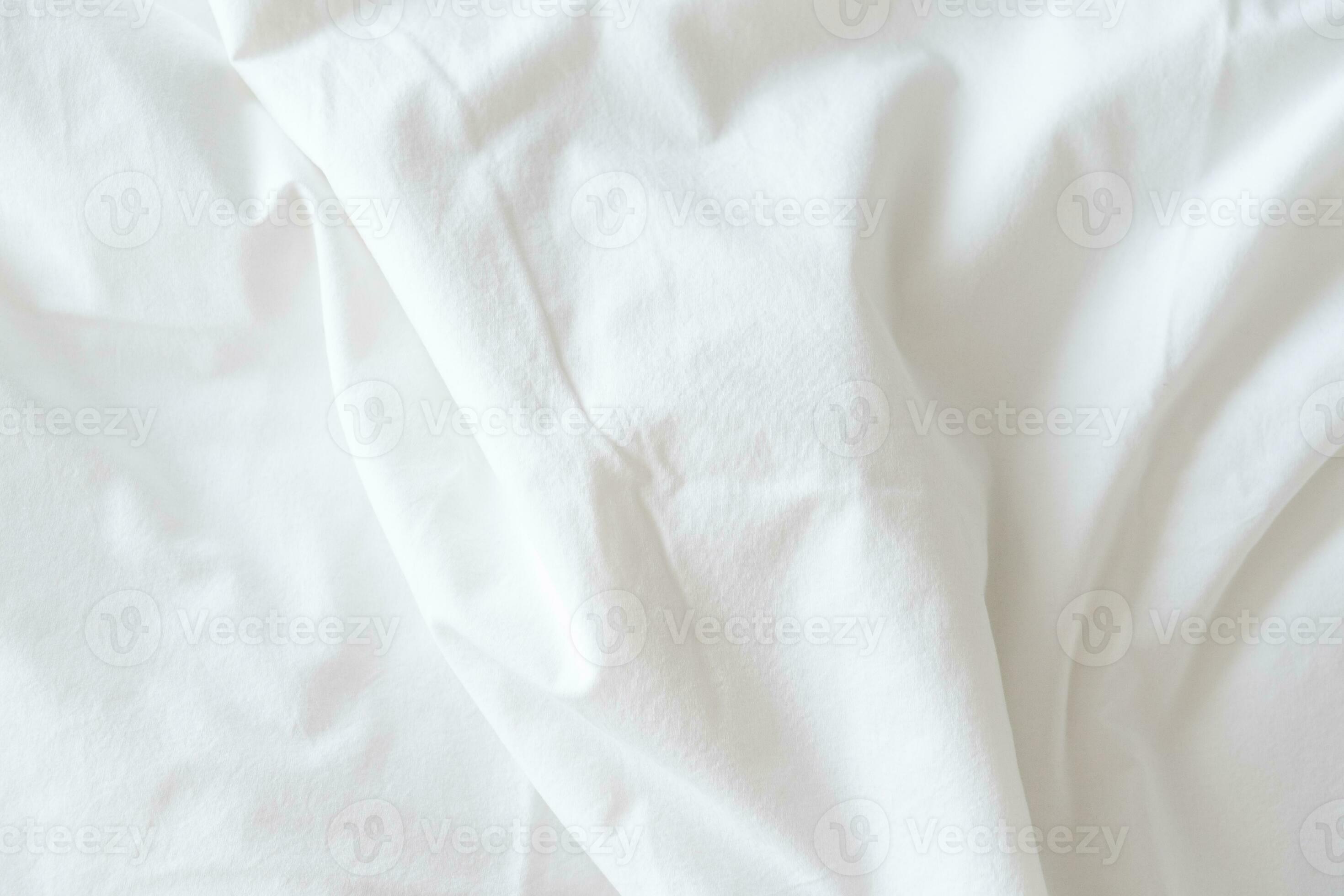 Abstract pattern of white crumpled bed sheet. White wrinkled fabric