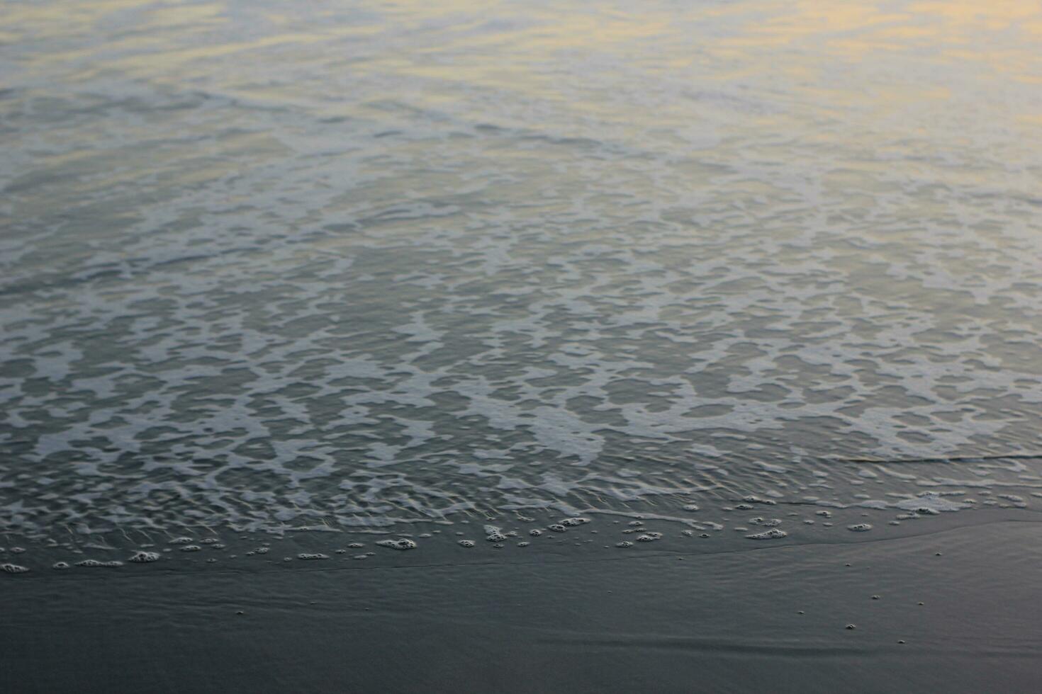 seawater foam on the beach sand photo
