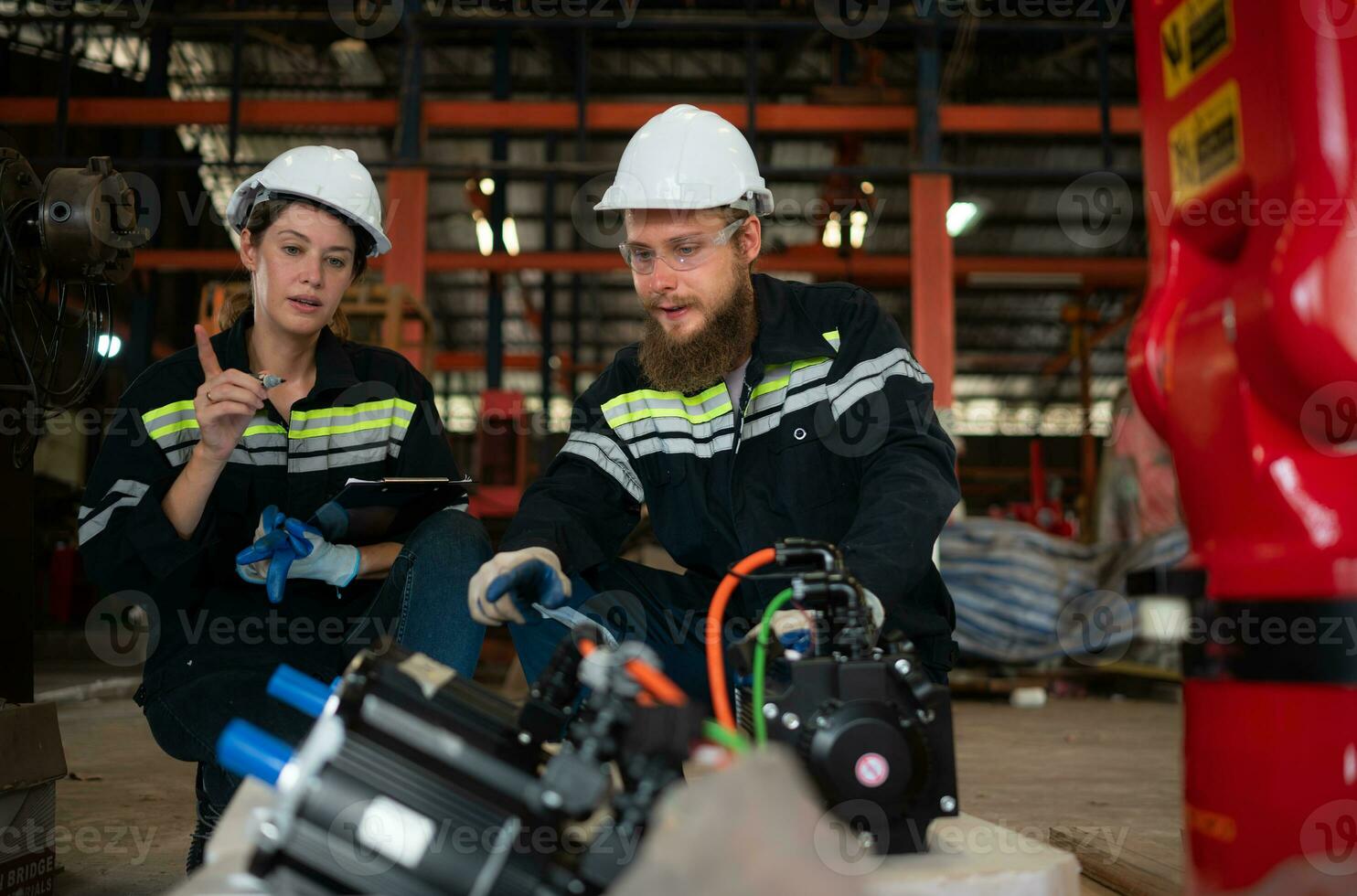 Both of engineers installing a small robotic arm is being installed for testing. before sending to customers for industrial use. photo