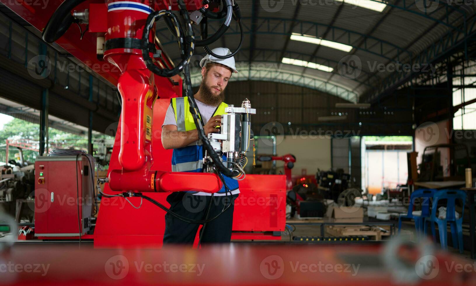 An engineers installing and testing a large robotic arm. before sending it to customers for use in the industry photo