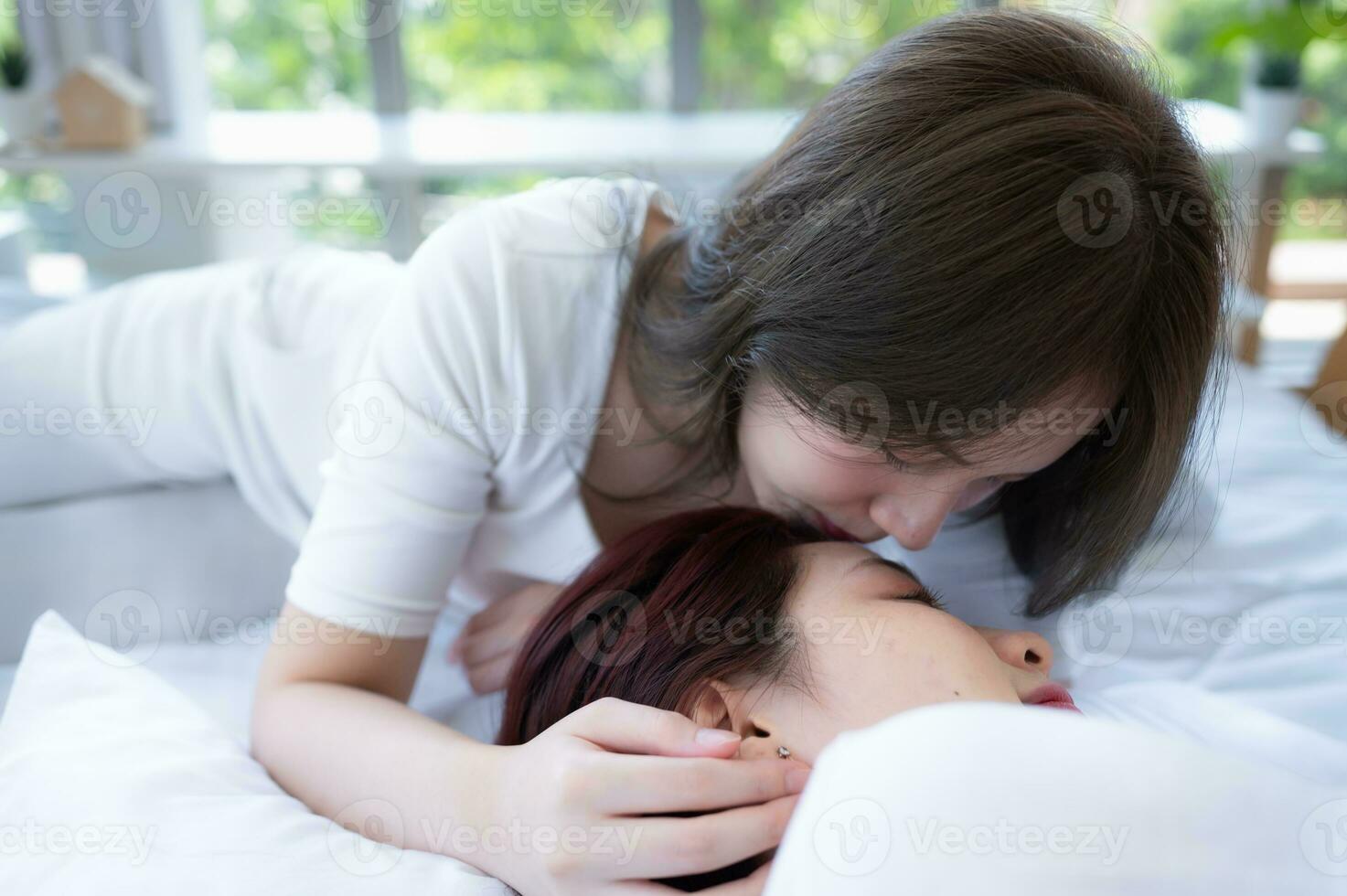 en el blanco cama, un lgbt parejas felizmente toque y caricia cada otro foto