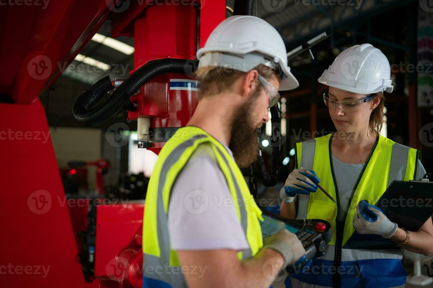 Both of engineers installing and testing a large robotic arm. before sending it to customers for use in the industry photo