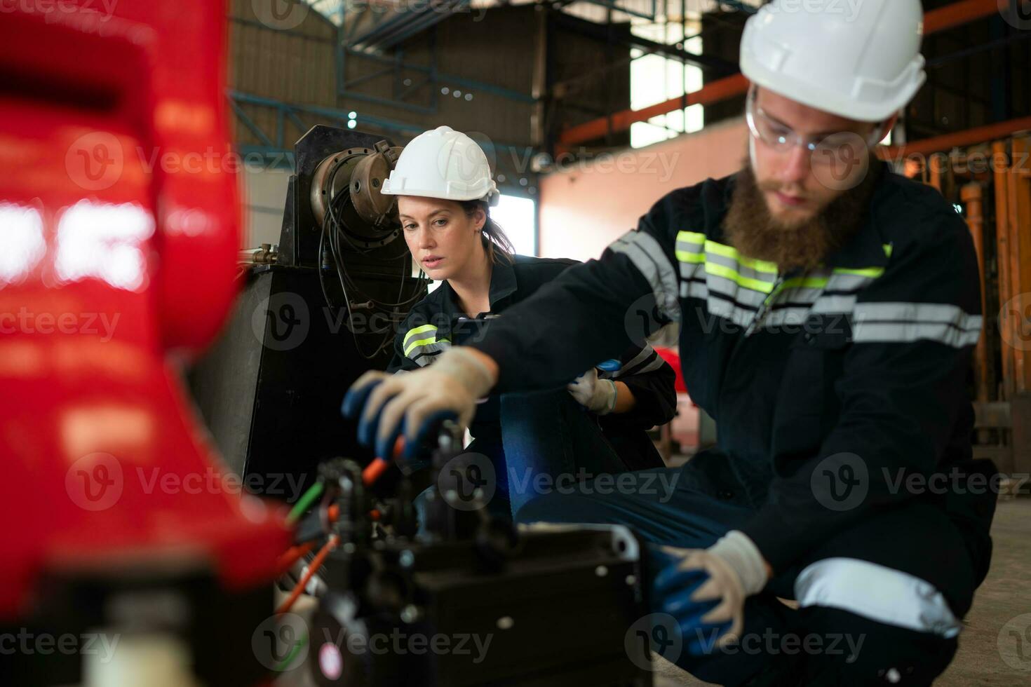 Both of engineers installing a small robotic arm is being installed for testing. before sending to customers for industrial use. photo