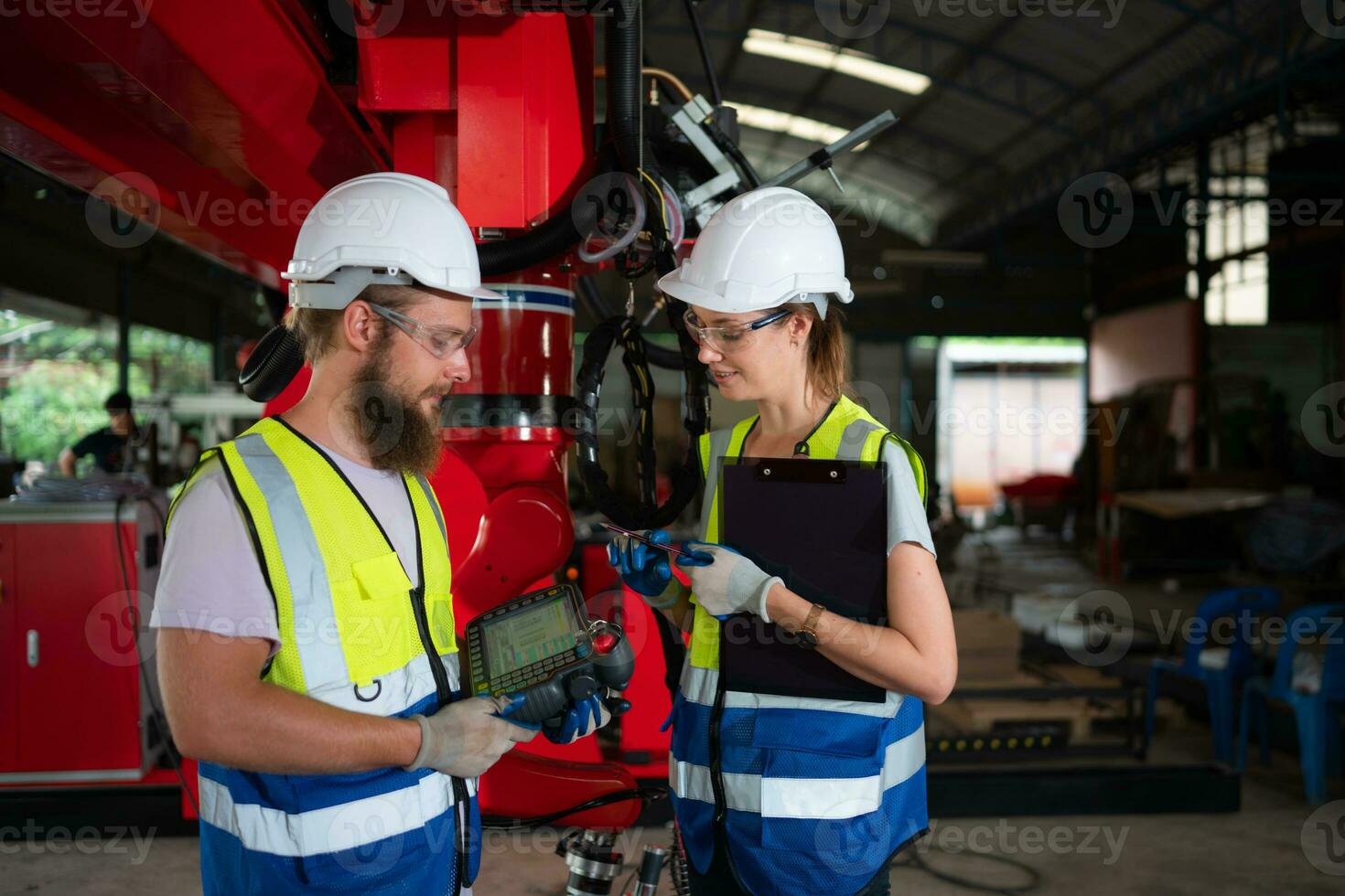Both of engineers installing and testing a large robotic arm. before sending it to customers for use in the industry photo