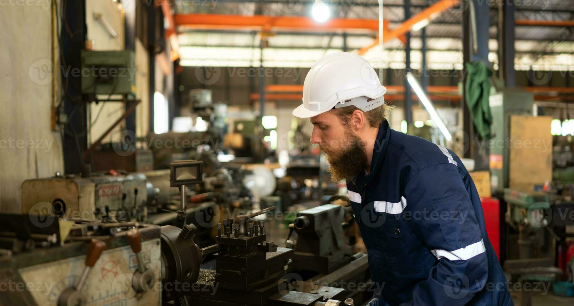 Portrait of mechanical engineers are checking the working condition of an old machine that has been used for some time. In a factory where natural light shines onto the workplace photo