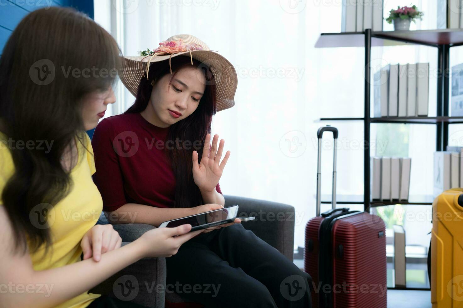 In the living room, an LGBT couple sits on the sofa searching for traveling to do this weekend photo