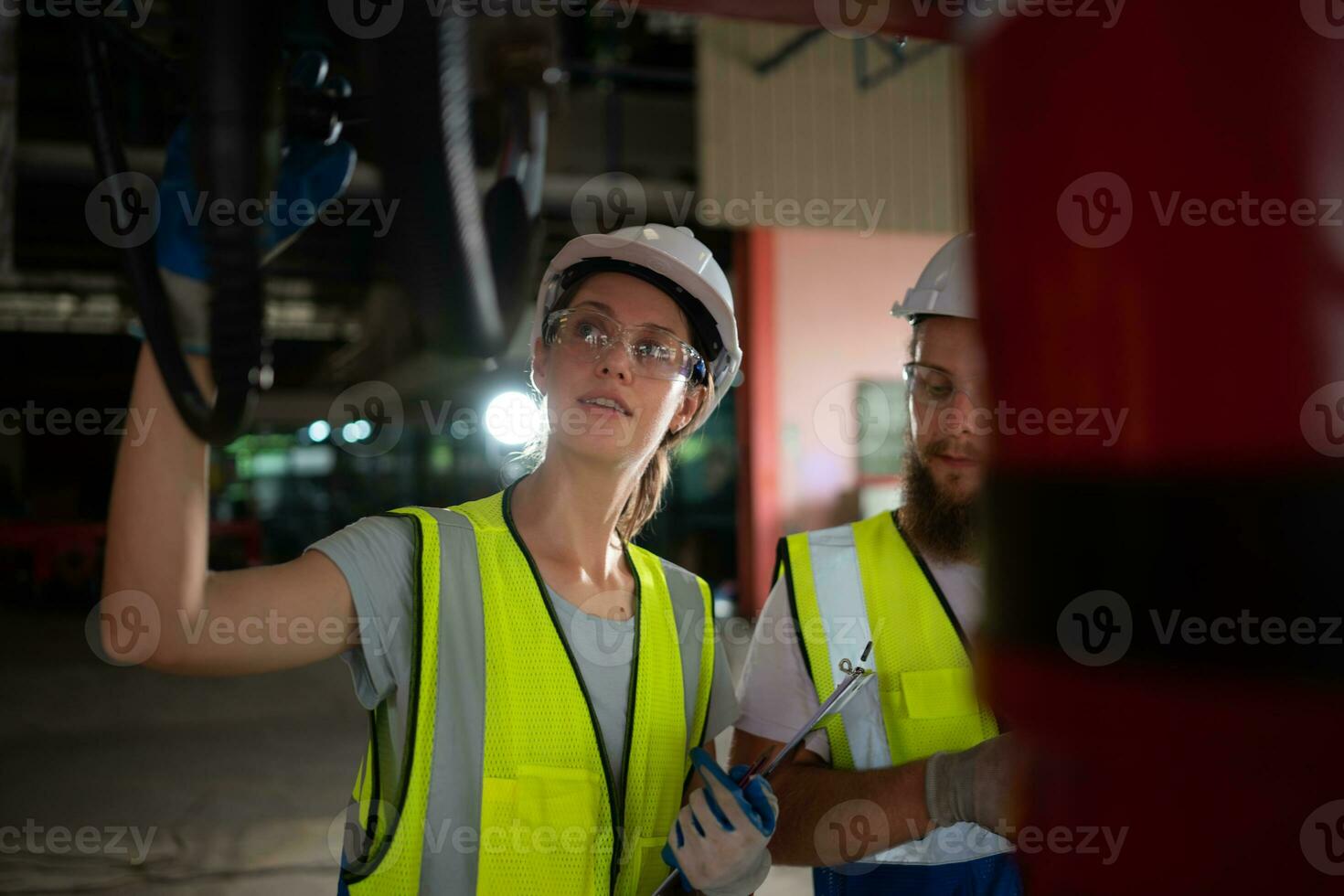 Both of engineers installing and testing a large robotic arm. before sending it to customers for use in the industry photo