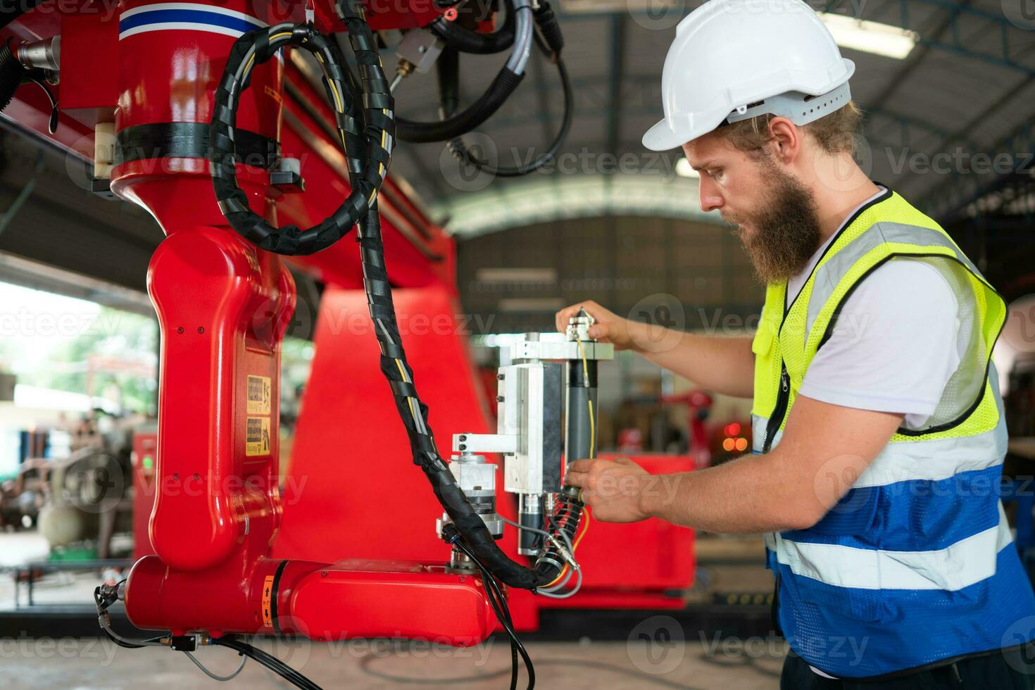 An engineers installing and testing a large robotic arm. before sending it to customers for use in the industry photo