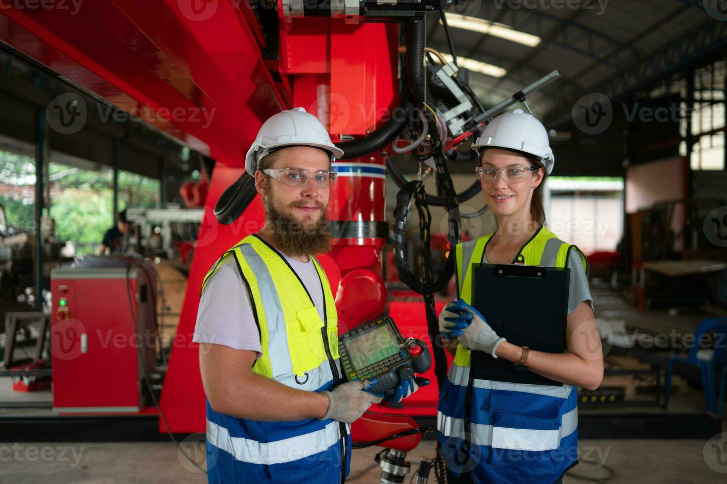 Both of engineers installing and testing a large robotic arm. before sending it to customers for use in the industry photo