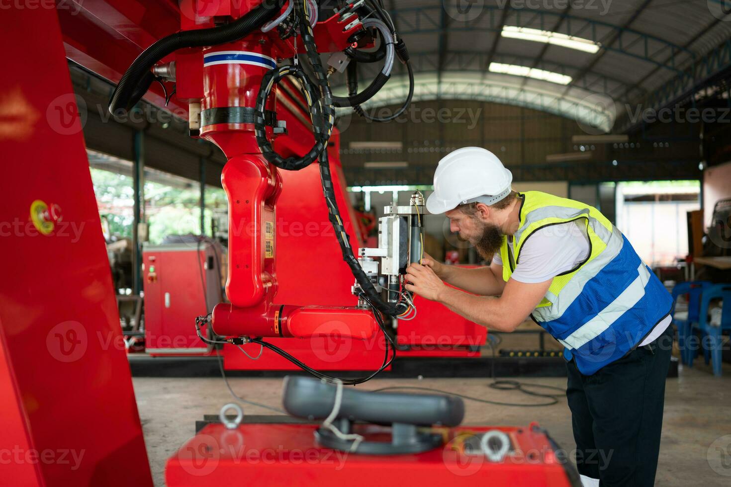 An engineers installing and testing a large robotic arm. before sending it to customers for use in the industry photo
