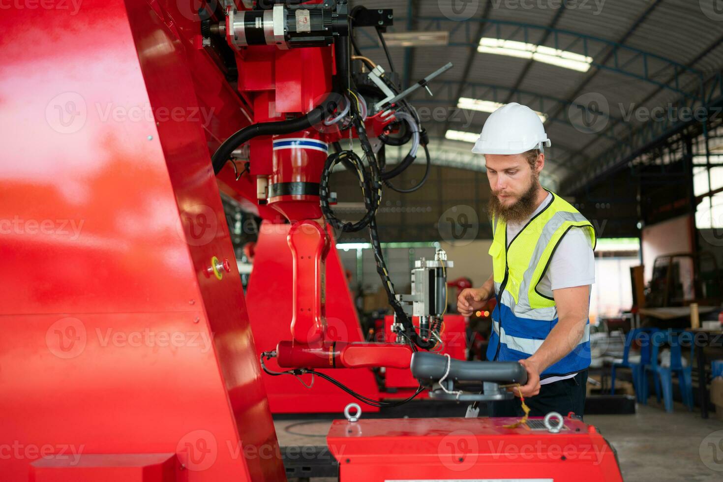 An engineers installing and testing a large robotic arm. before sending it to customers for use in the industry photo