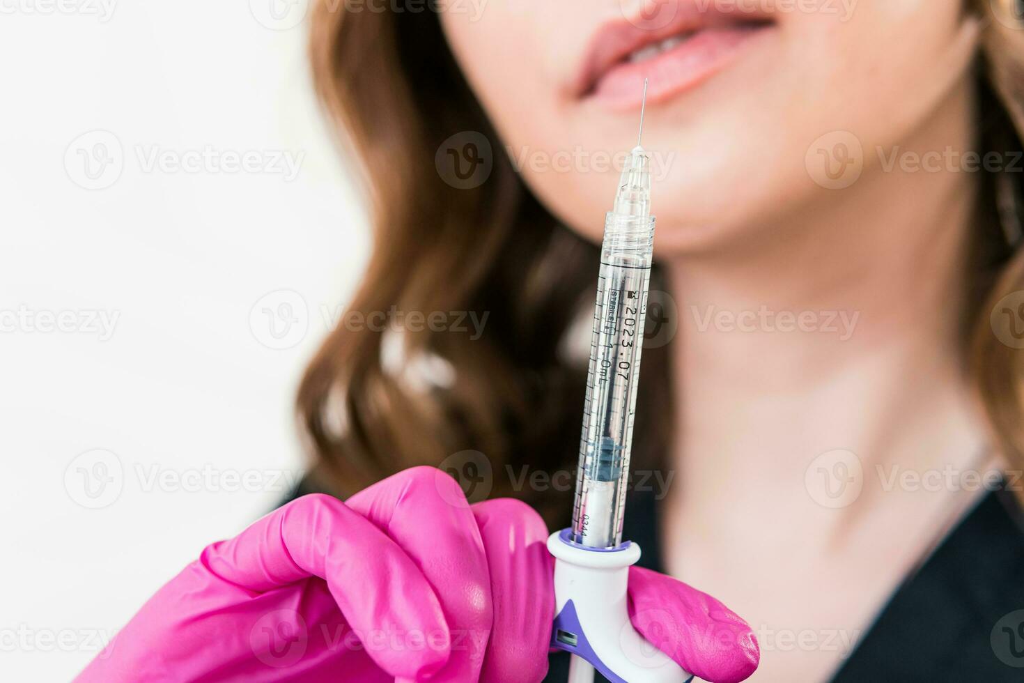 Close-up of female beautician doctor holding syringe with beauty injections photo