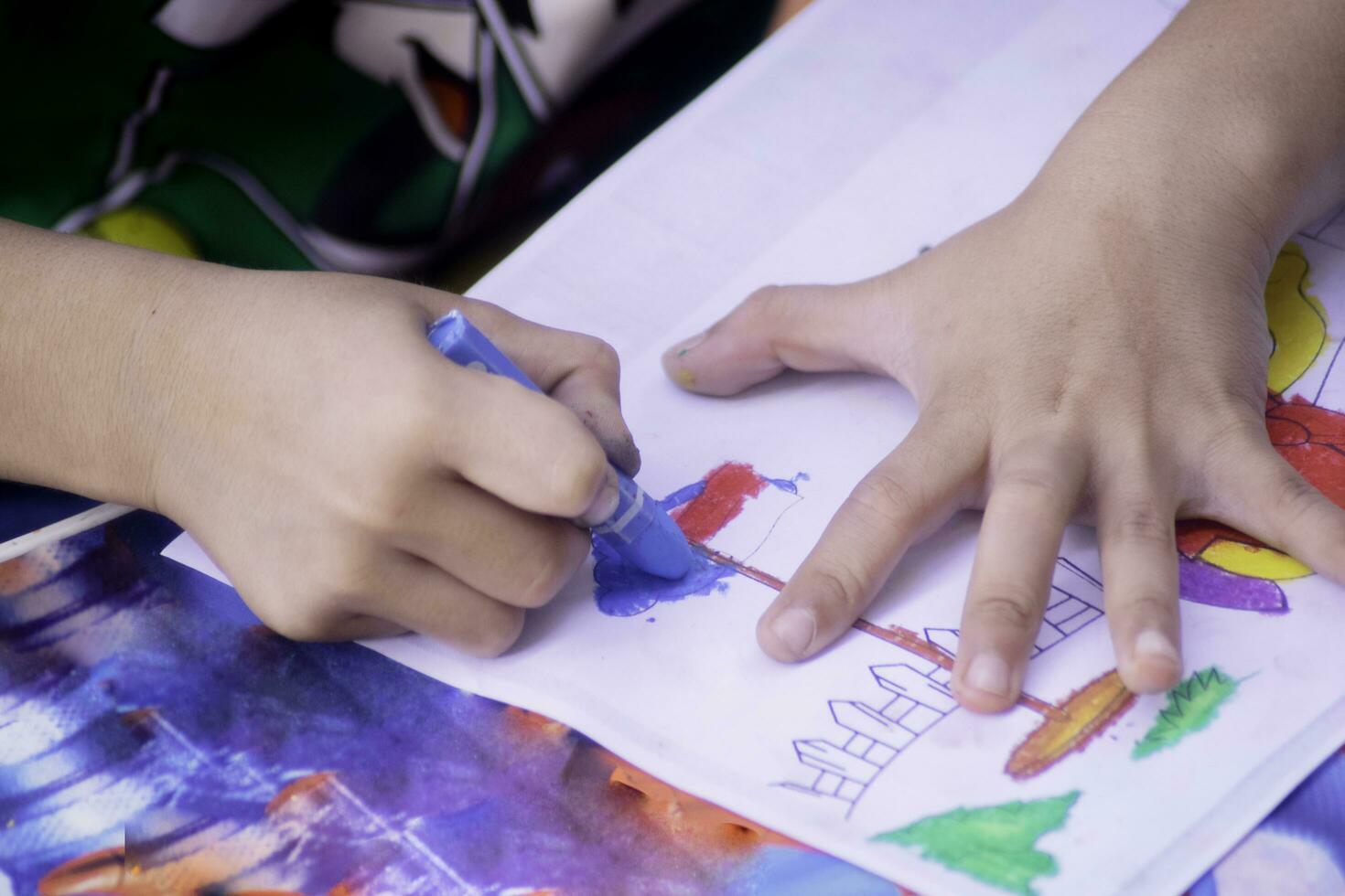 kid hand with coloring pencil. drawing activity photo