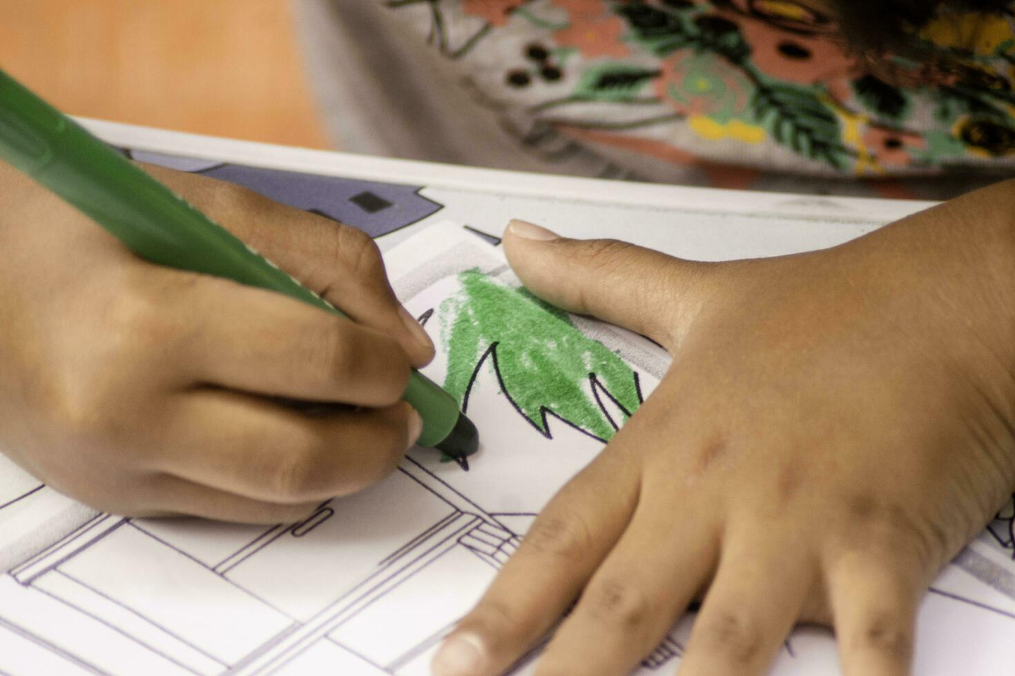 kid hand with coloring pencil. drawing activity photo