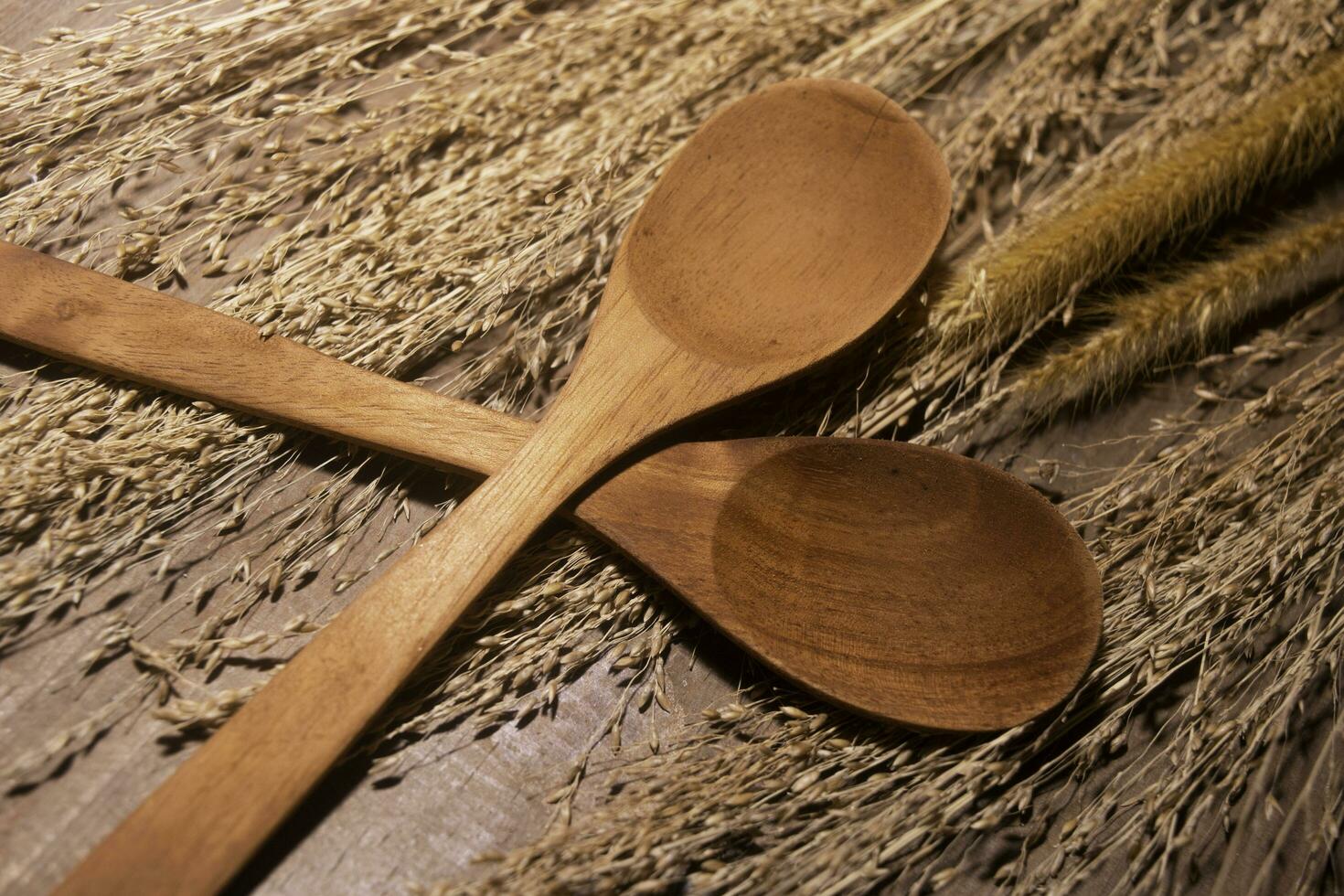 wooden spoon and dry reeds on wooden table photo