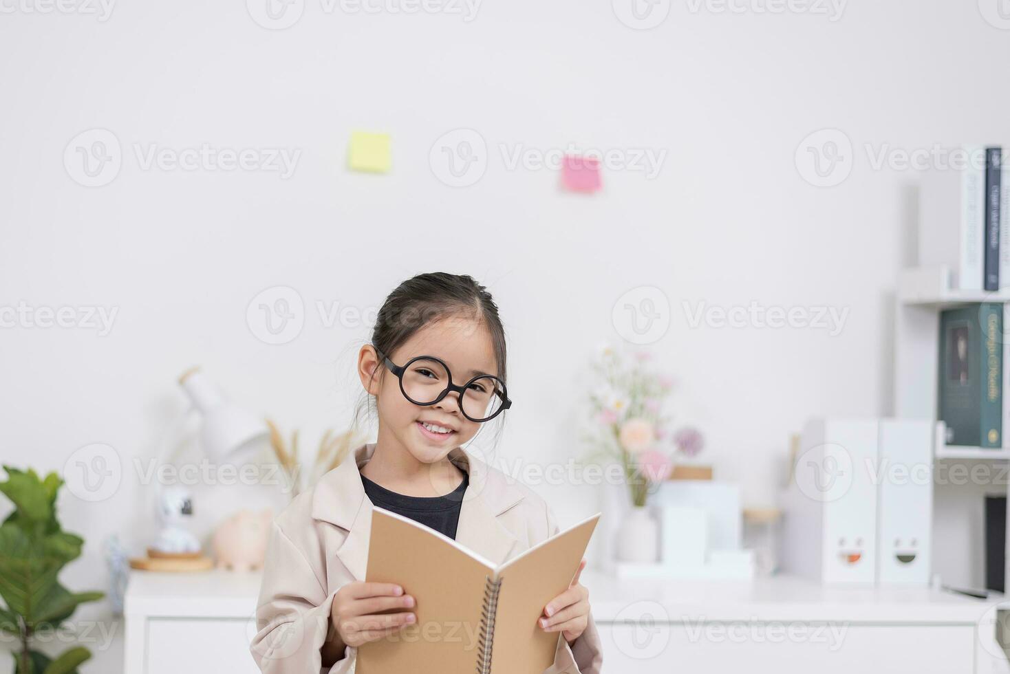 Little business lady Asia. formalwear sitting at the table and holding a notebook photo