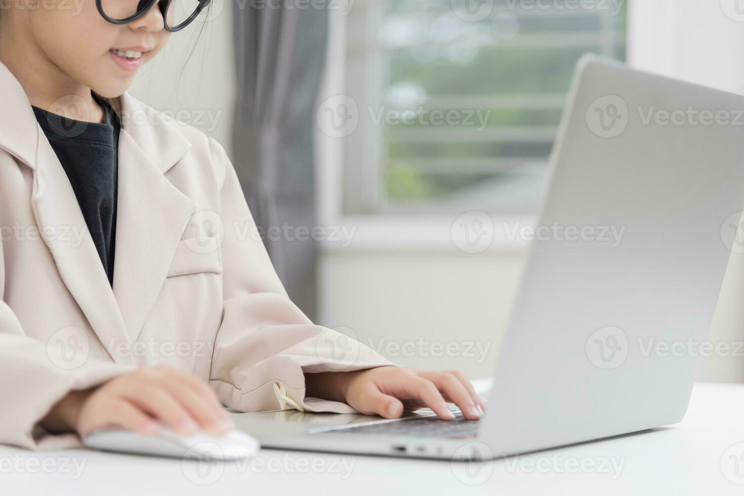 Little business lady Asia. formalwear sitting at the table and using laptop photo