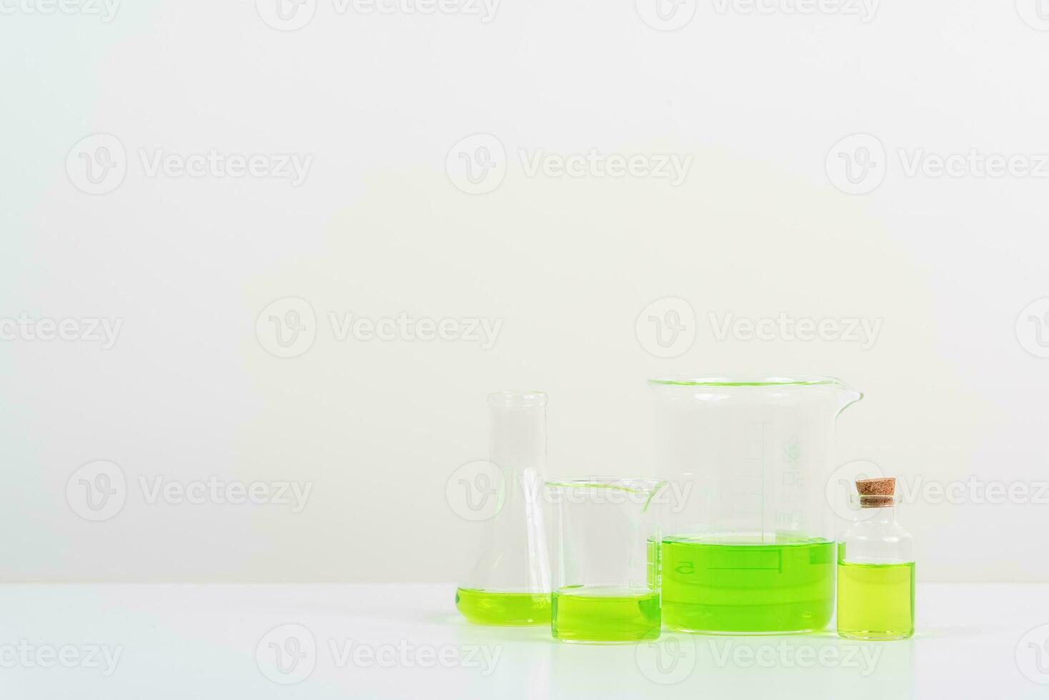 some test tube on the white table  with beakers, flasks, and test tubes filled with colorful liquids photo