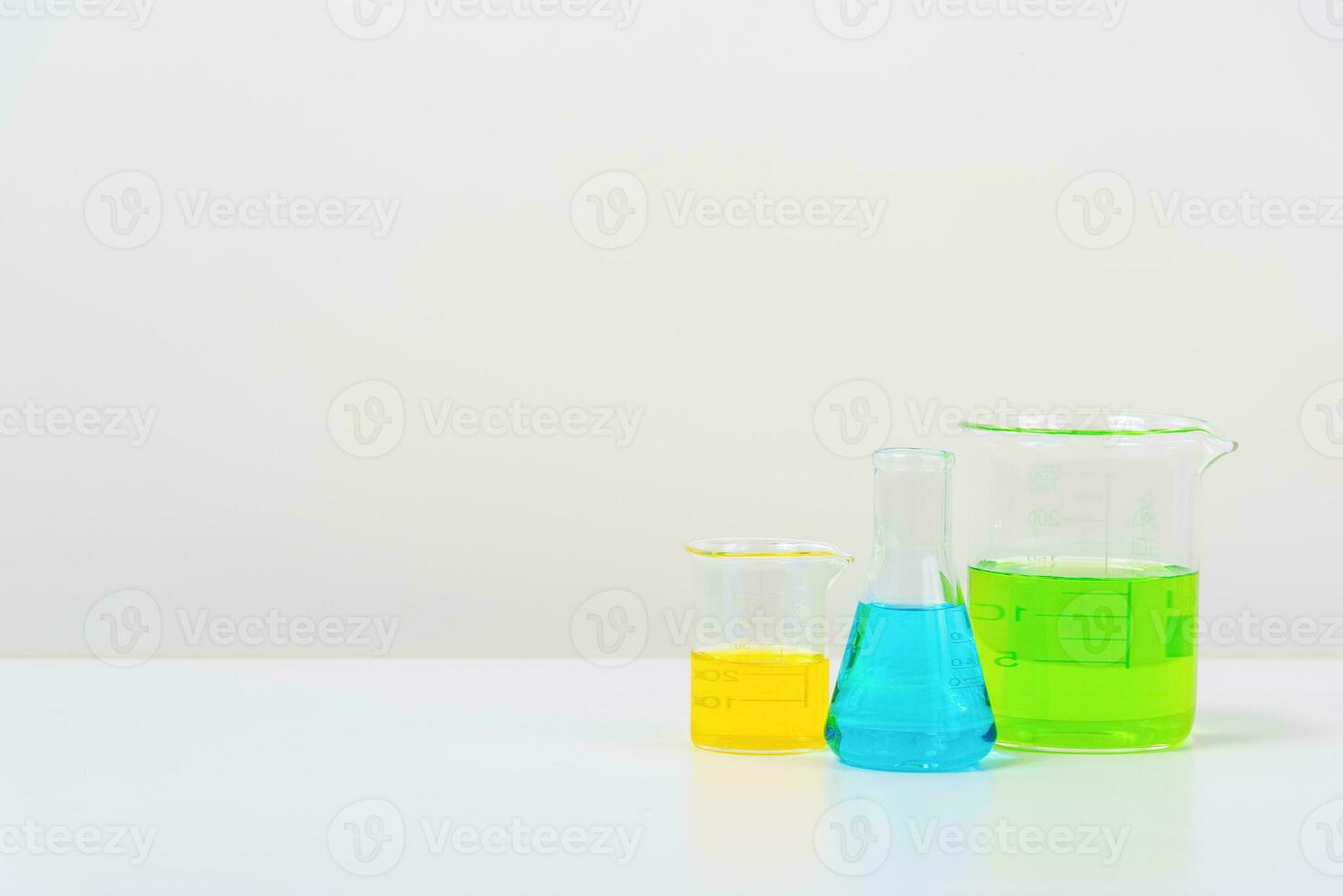 some test tube on the white table  with beakers, flasks, and test tubes filled with colorful liquids photo