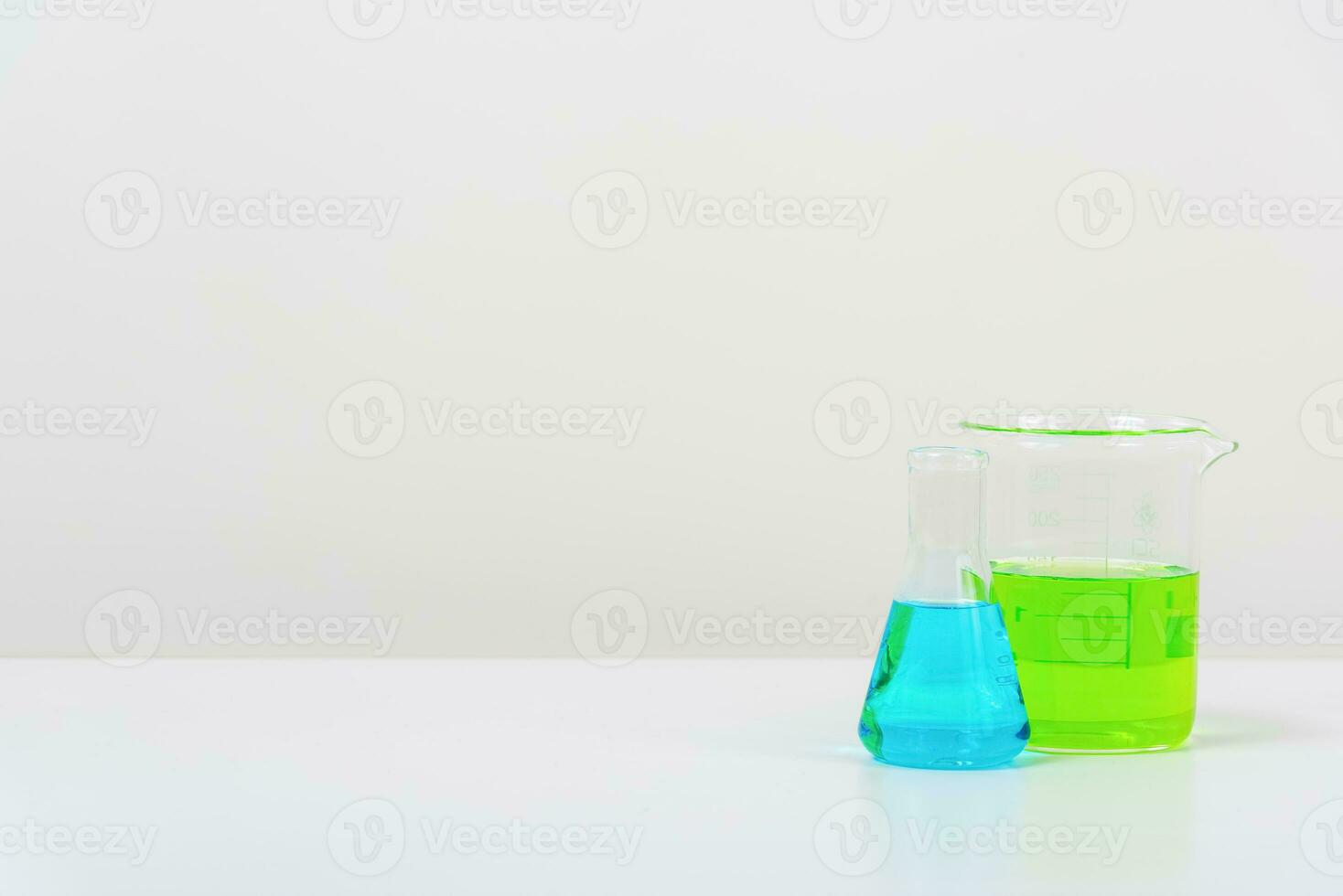 some test tube on the white table  with beakers, flasks, and test tubes filled with colorful liquids photo