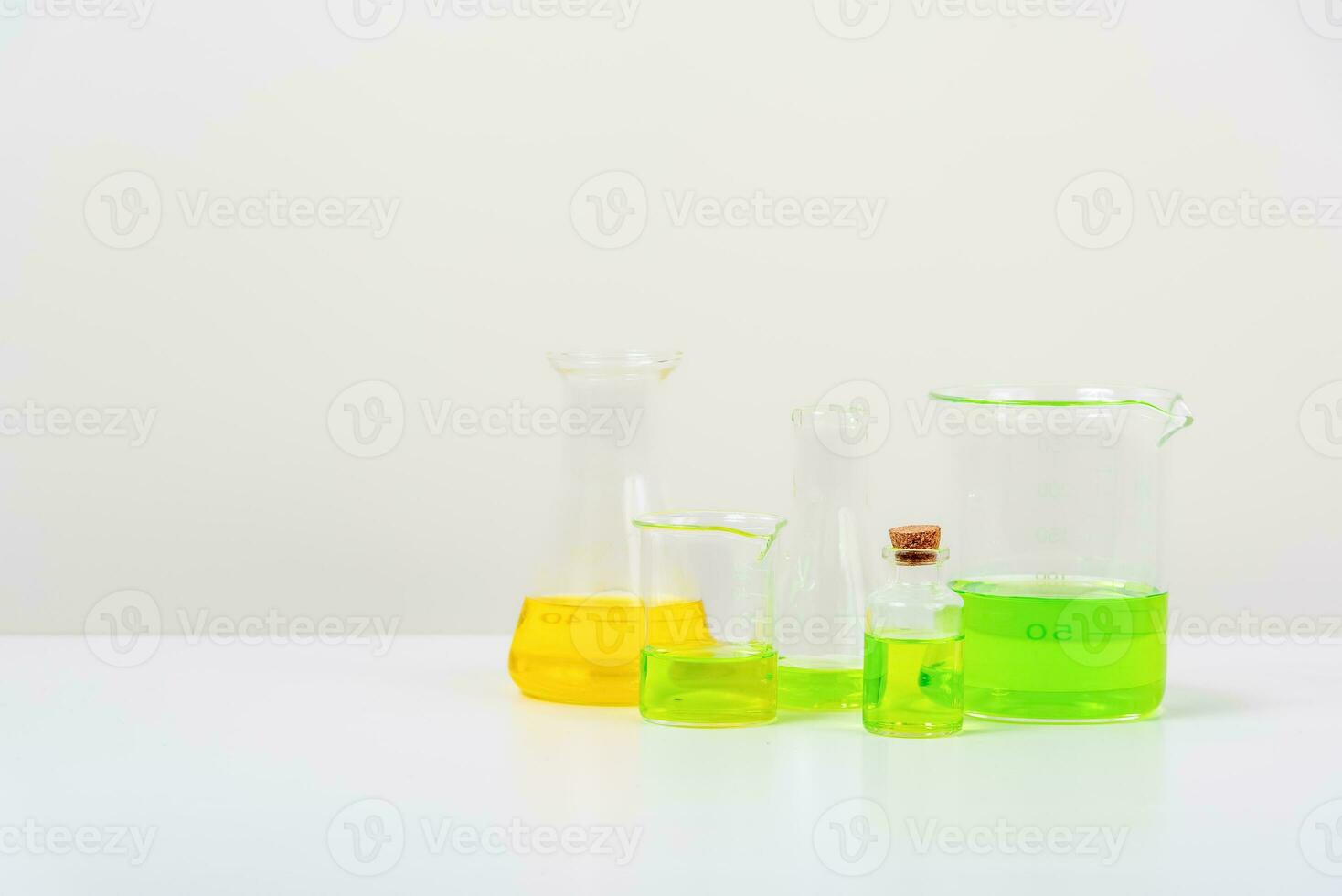 some test tube on the white table  with beakers, flasks, and test tubes filled with colorful liquids photo