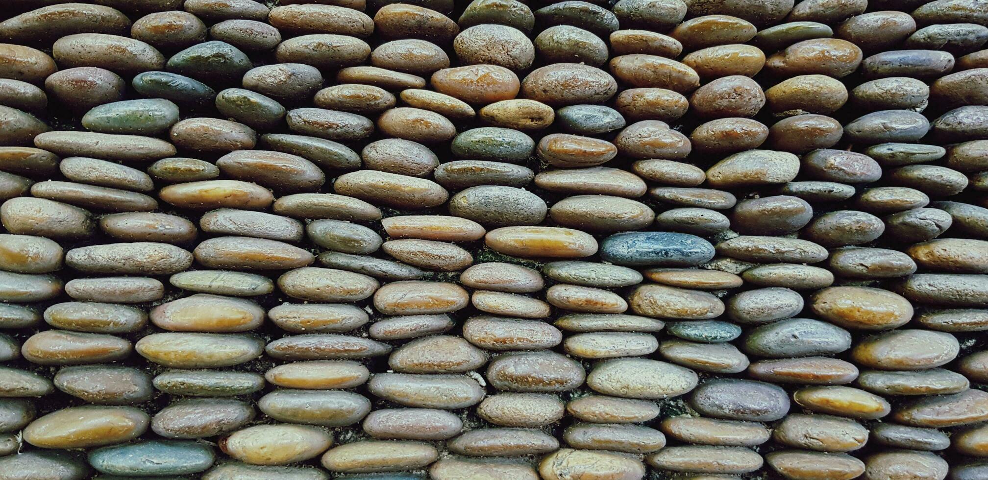 Many small brown pebble or gravel wall for background. Art wallpaper, Abstract background, Design and Decoration concept photo