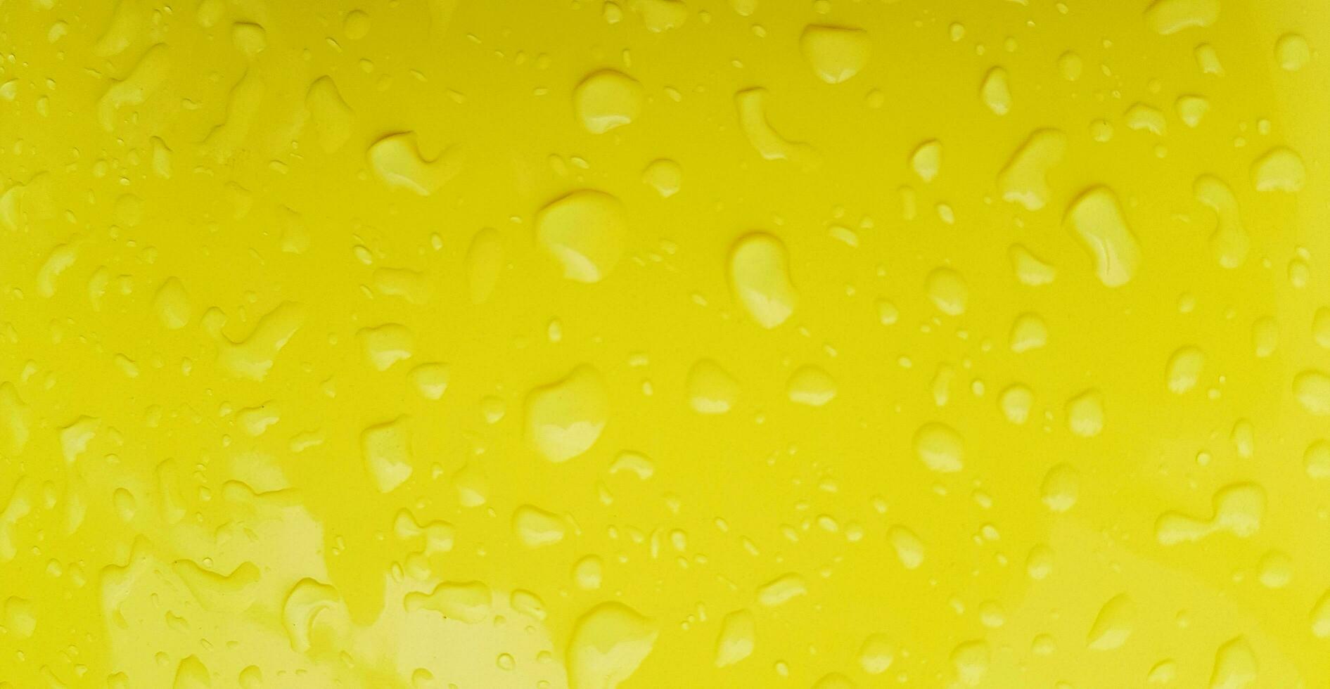 Raining water drop on yellow plastic table  after rainy day for background. Art or Abstract, Wallpaper, Colorful and Pattern photo