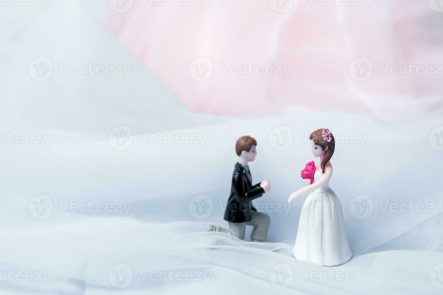 Golden wedding rings for engagement. Marriage golden rings with white, pink ribbons background. Rings on the white and red rose. The marriage rings is the symbol of traditional wedding of pair lovers. photo