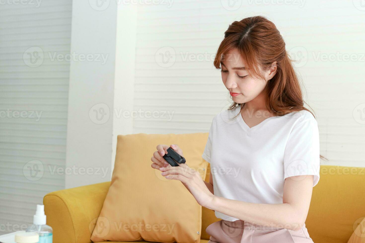 Asian women live at home Use a fingertip oxygen meter. To measure the oxygen concentration in the bloodstream. Concept of prevention of coronavirus. Treatment at home. home isolation photo