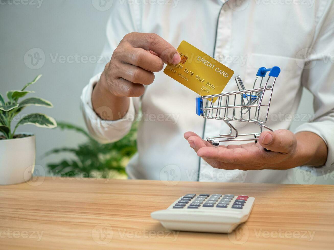 Man holding a credit card and pressing a calculator. Shopping concept. Cashless payment concept. photo