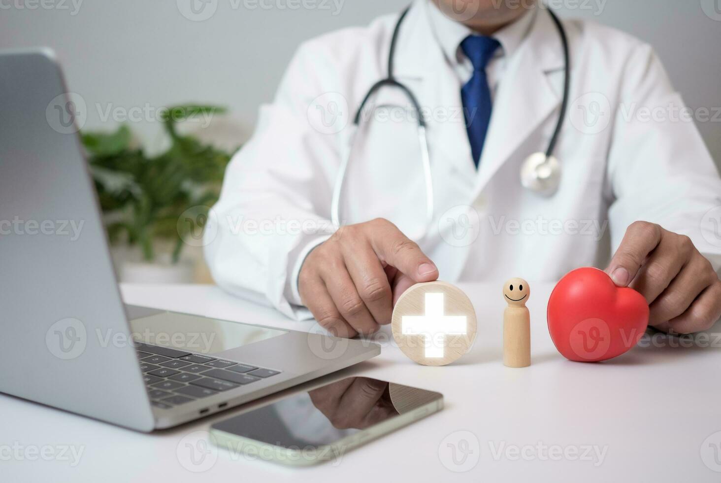 The doctor shows a wooden doll, a plus sign, and a red heart at the hospital. Medical health care and medical services. Insurance concept. photo